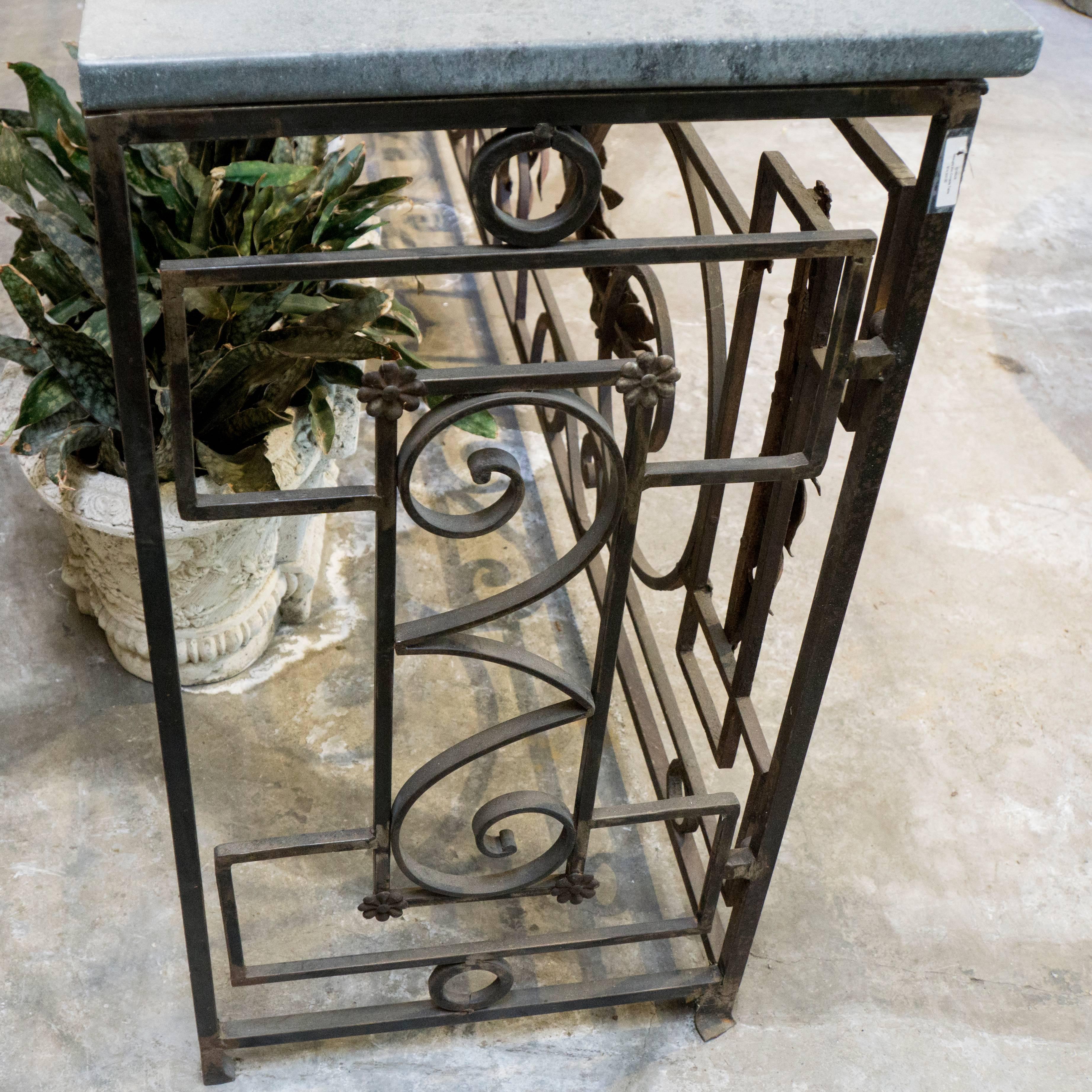 Antique French console table, circa 1880, featuring creative wrought iron spiral and box design with decorative leaf accents. New stone table surfaces are in three pieces, each one is about 33 inches long. They are a cool dark grey, smooth and full