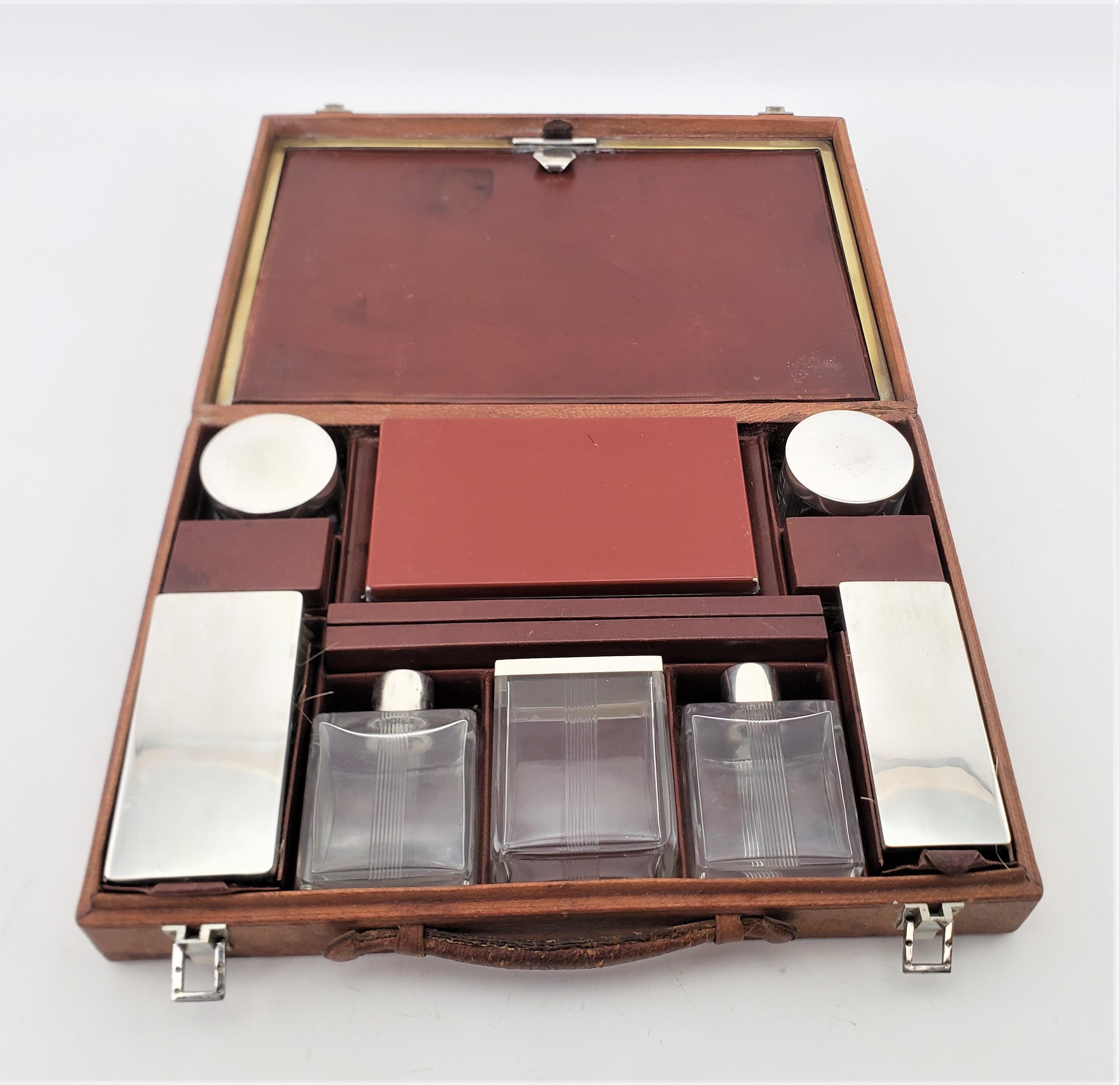 This travelling dresser or vanity set is unsigned, but presumed to have originated from France and date to approximately 1920 and done in the period Art Deco style. The set is composed of a series of leather covered boxes and two jars, two bottles