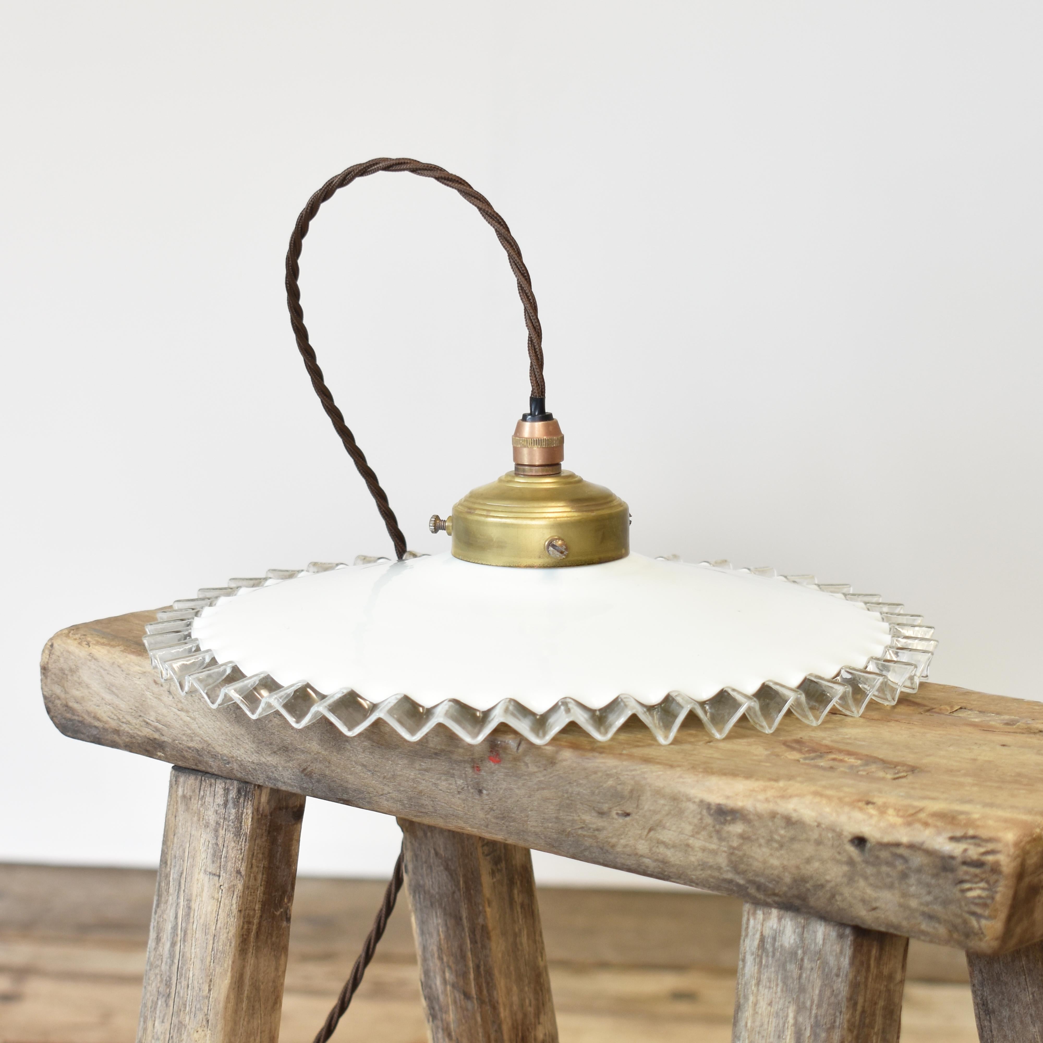 Antique French Coolie Milk Glass Frill Pendant Light – A

An early French glass coolie pendant light. The conical milk glass shade has been hand spun from opaque glass with a clear frilly edge. The light has an aged brass gallery. Great as a pendant