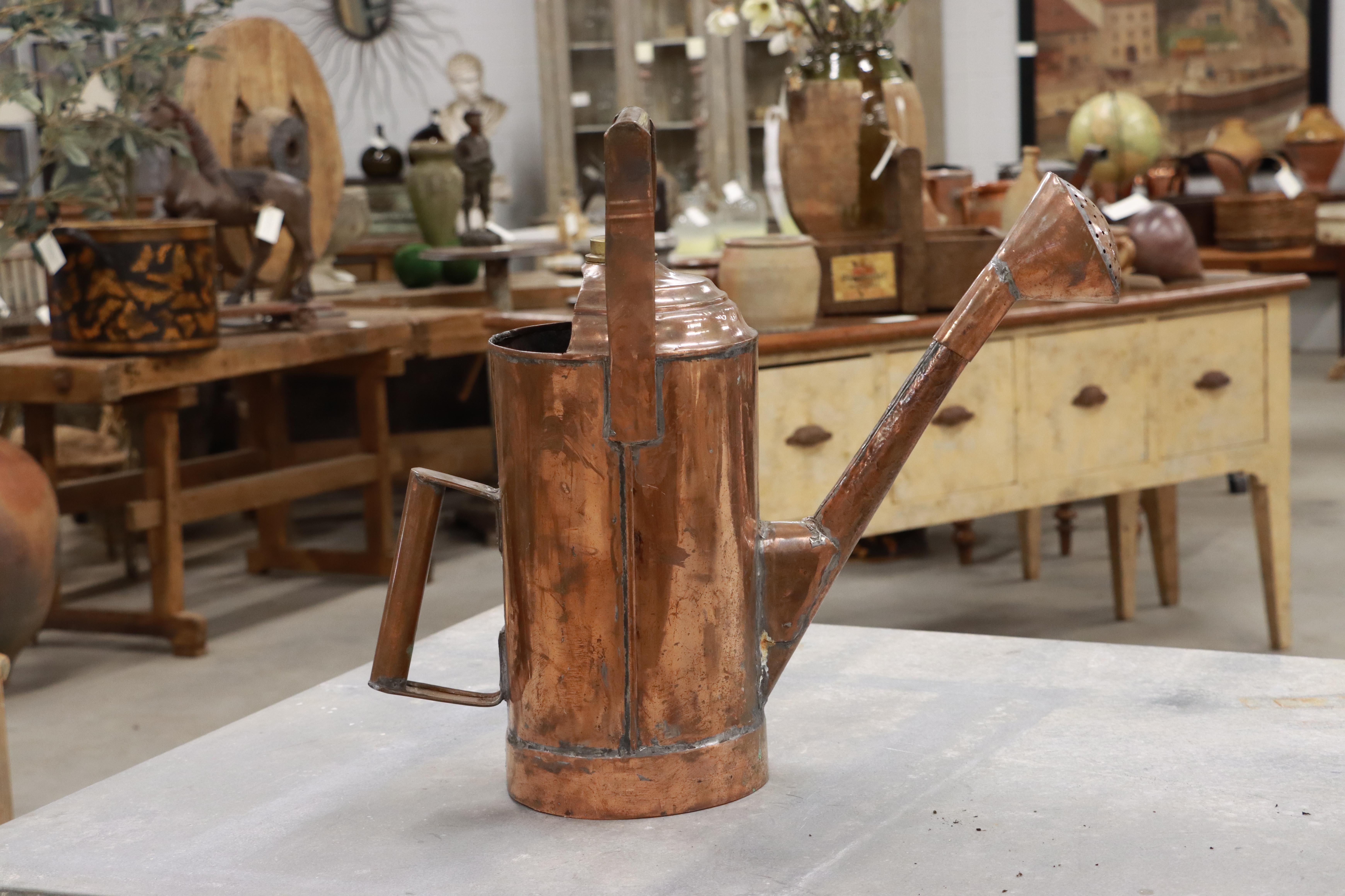 Very unusual two handled tall cylindrical antique French copper watering can with its original rose.

The second handle on a watering can was invented by Englishman, John Hawes in the 1880s. It became much easier and more balanced to water flowers