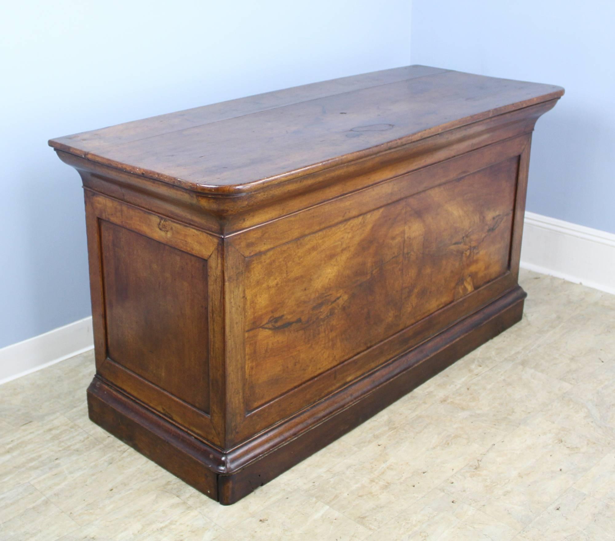 A fantastic desk created from a French commercial counter. French sensibility on the front - Louis Philippe style mouldings at top and bottom with a gloriously grained walnut facade. Go around the other side and you have an oak desk with a decidedly