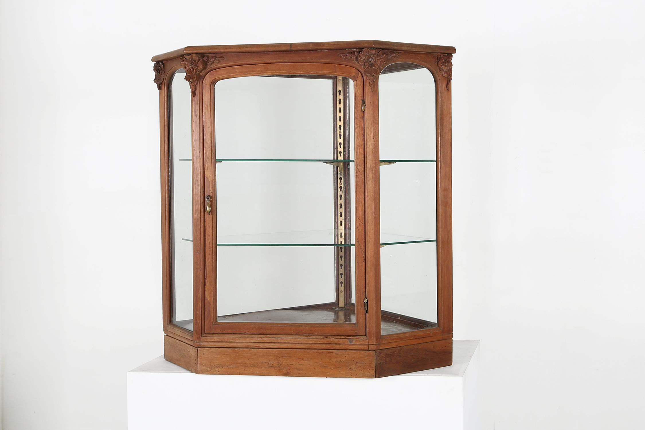 France / 1900 / counter display case / oak, wood / Romantic / Antique

Antique five-sided counter display case in oak wood with two glass shelves. With beautiful sculpted roses in wood at the 4 front corners and nice hardware. This elegant, hand