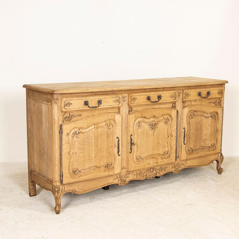 This 6 1/2' long sideboard shows off its French country style in the carved panels and lovely details along the skirt, door & drawer panels. The bleached oak finish gives it a fresh and welcoming look for today's modern home and it sits gracefully