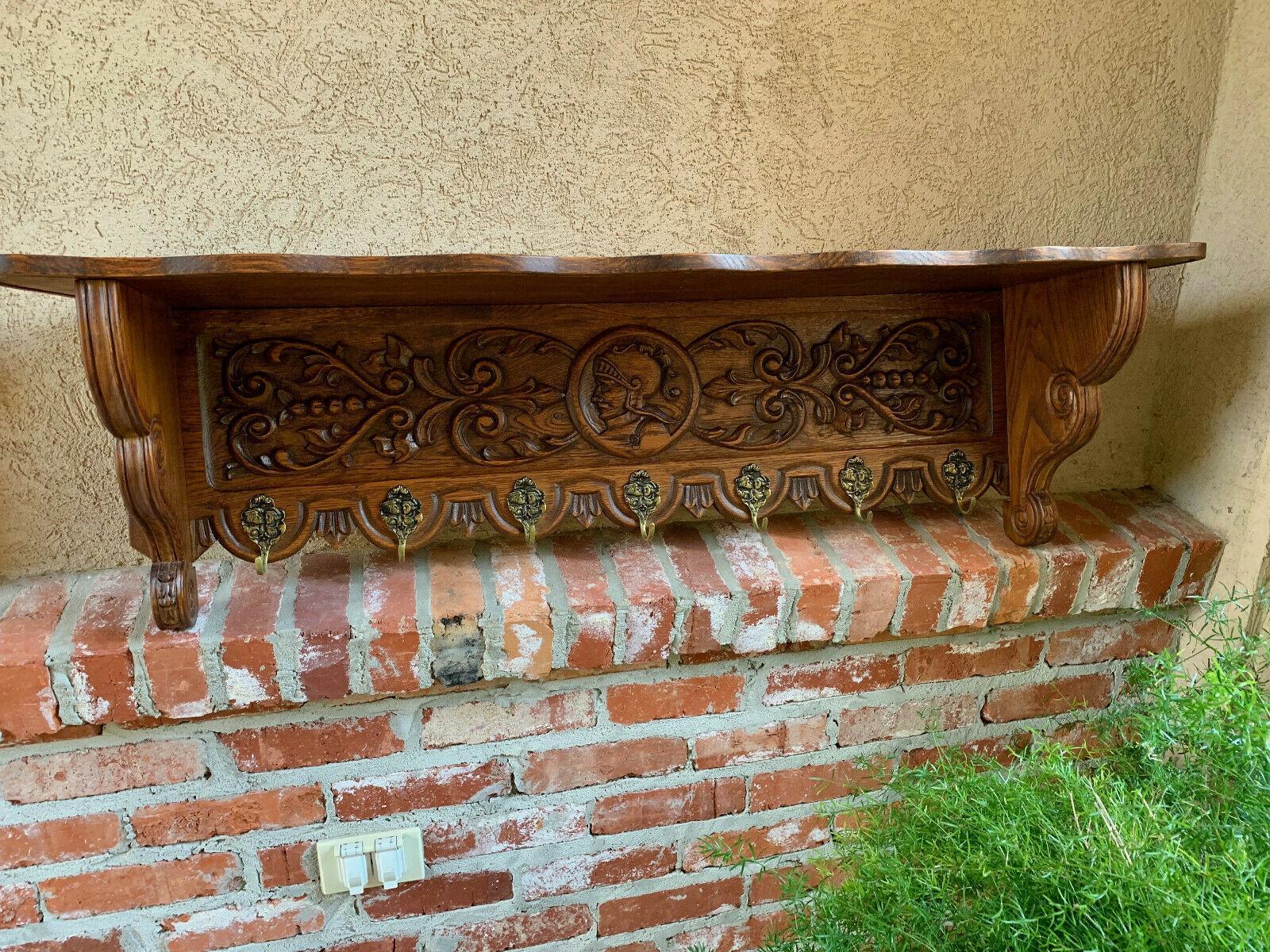 ~Direct from France~
Another lovely antique wall shelf, this one having beautiful oak grain and a large carved center panel!
~Carvings include a center medallion with a warrior figurehead surrounded by ornate scrolls and filigree~
~Seven brass