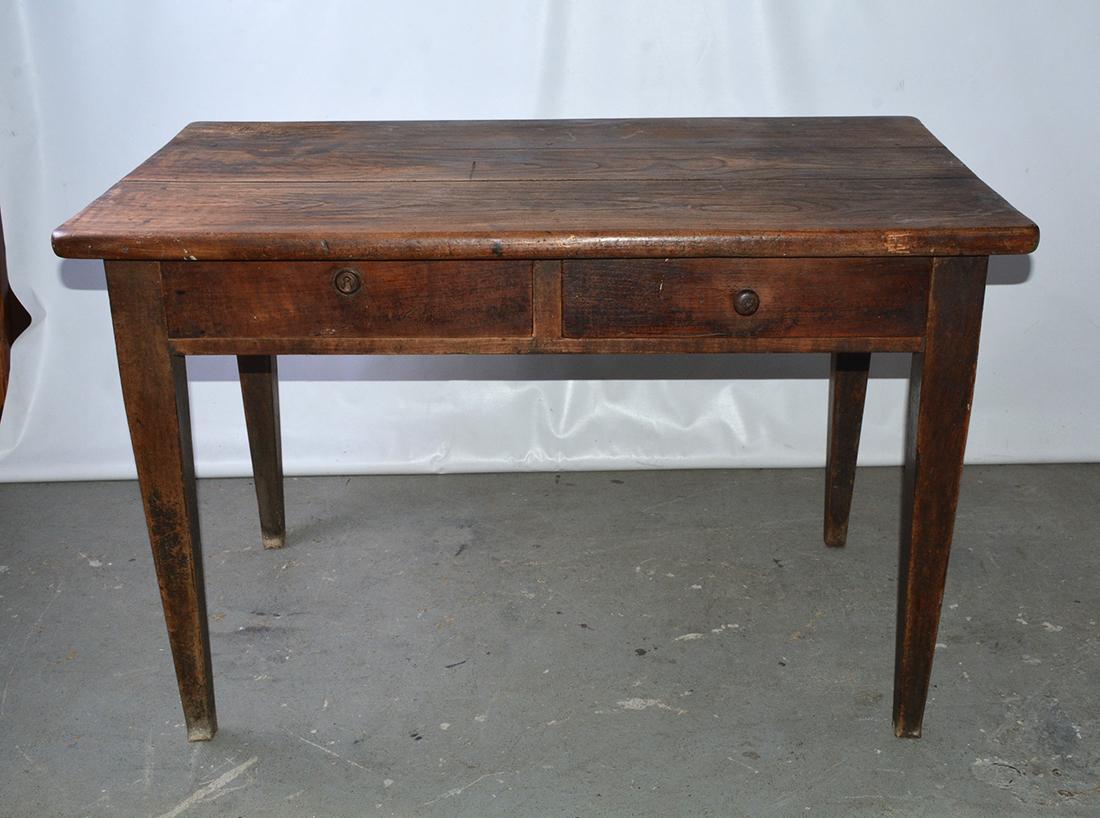 The rustic antique country desk, writing table or server made of chestnut has two deep, dovetailed drawers. The right one has a wooden pull and the left one has a lock and key. The legs are straight and beautifully tapered. The desk's simplicity