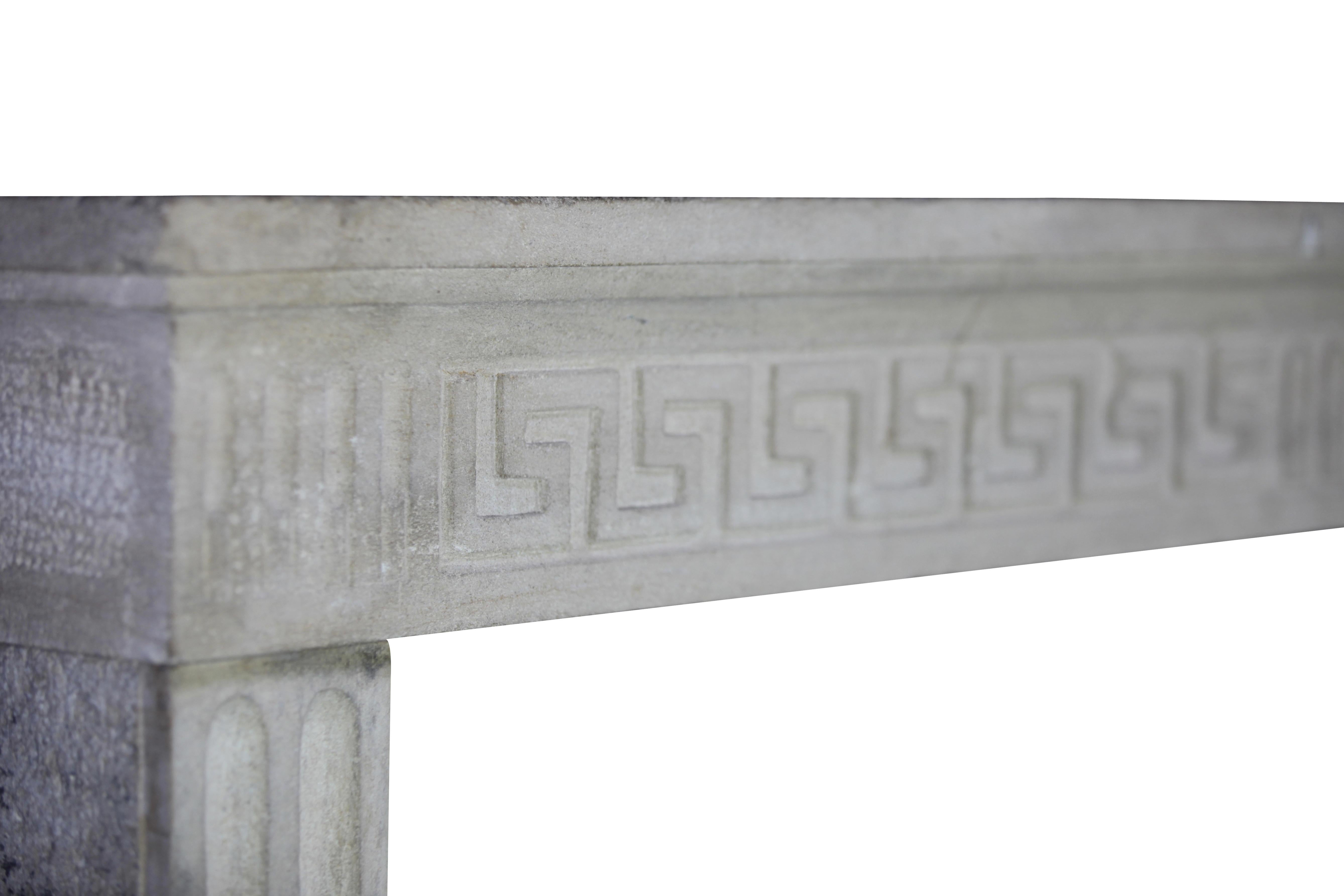 A French country in limestone original antique fireplace mantle. It has remains of the original patina. The Greek key carving is from The Louis XVI period, 18th century. The shelf can be restored. 
Measures: 
155 cm Exterior Width 61,02 Inch
104 cm