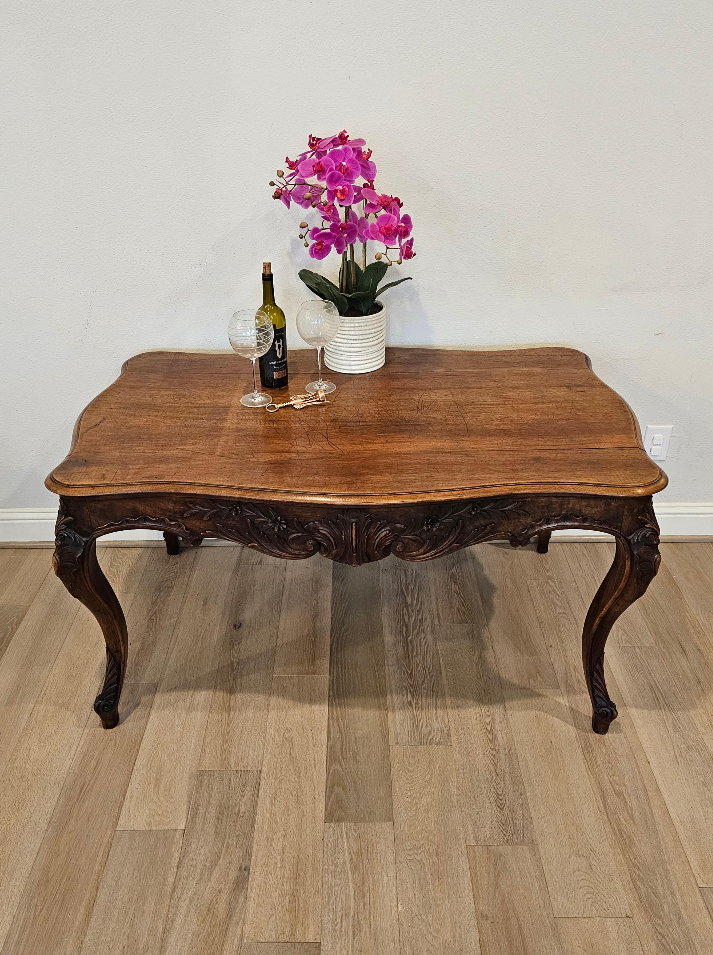 A large and exceptionally carved 19th century country French table with beautifully aged heavily worn warm rich dark patina. 

Hand-crafted in France, circa 1820, carved solid walnut, in elegant Louis XV taste, having a shaped top with molded