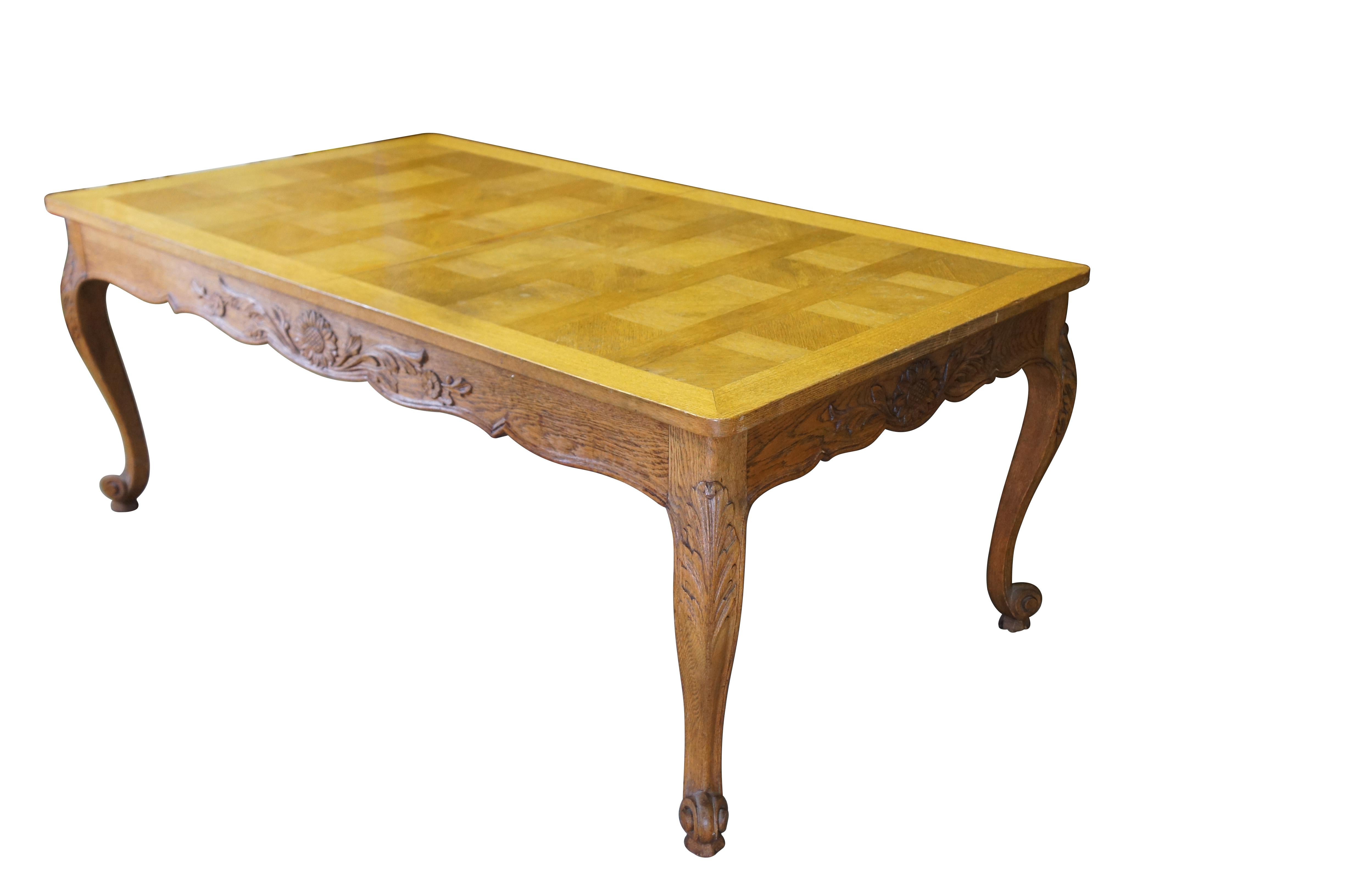 Antique French country / louis xv / farmhouse dining table.  Made of oak featuring a geometric parquetry top with serpentine skirt carved with floral sunflower and acanthus design, supported by thick scrolled cabriole legs.

Dimensions:
43