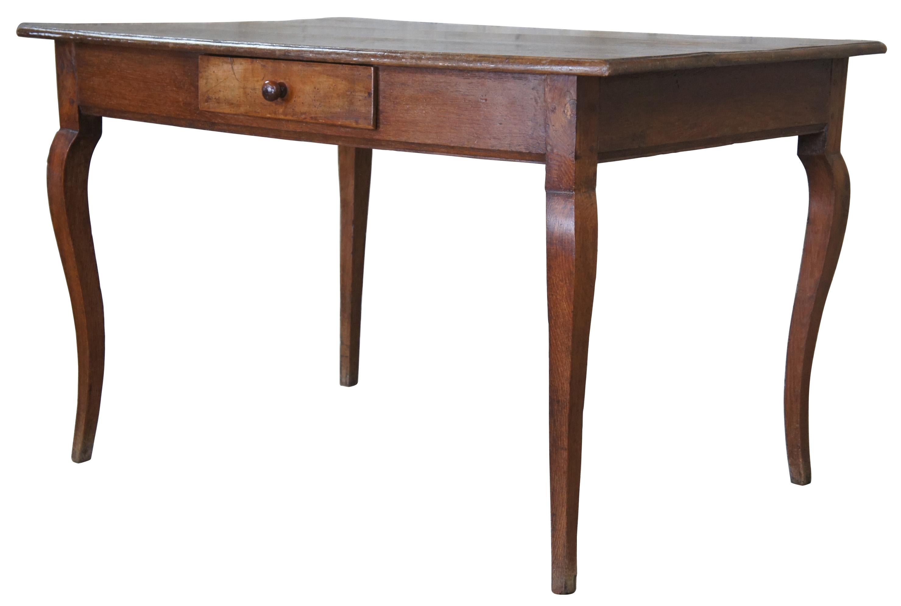 Early 20th century French Country writing desk. Made from oak with a rectangular form featuring a central drawer and cabriole legs. 
 