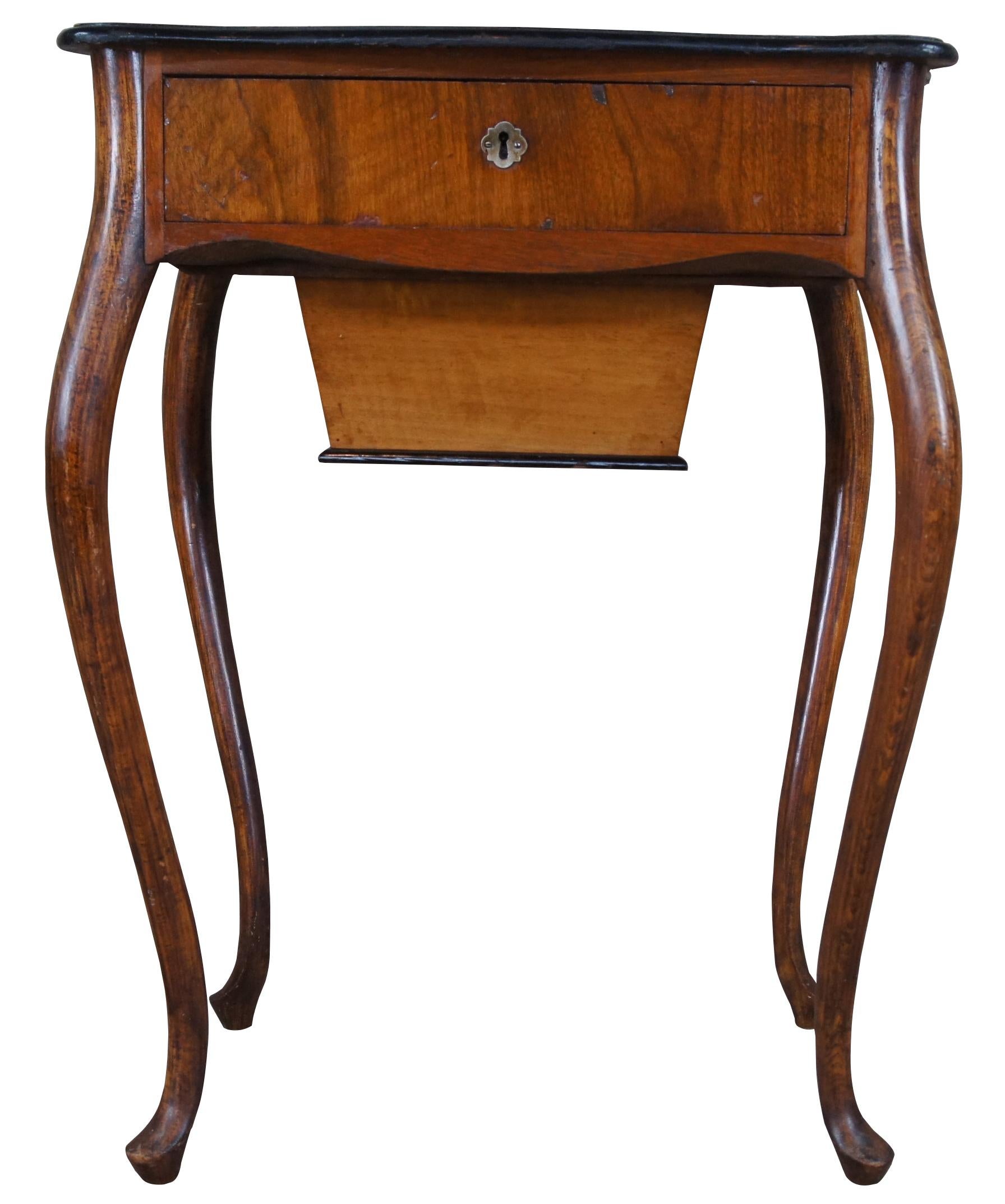 Table ou armoire de couture ancienne, vers les années 1910. Fabriqué en chêne et en noyer, il présente une forme serpentine avec un tiroir supérieur et un coffre inférieur.
 