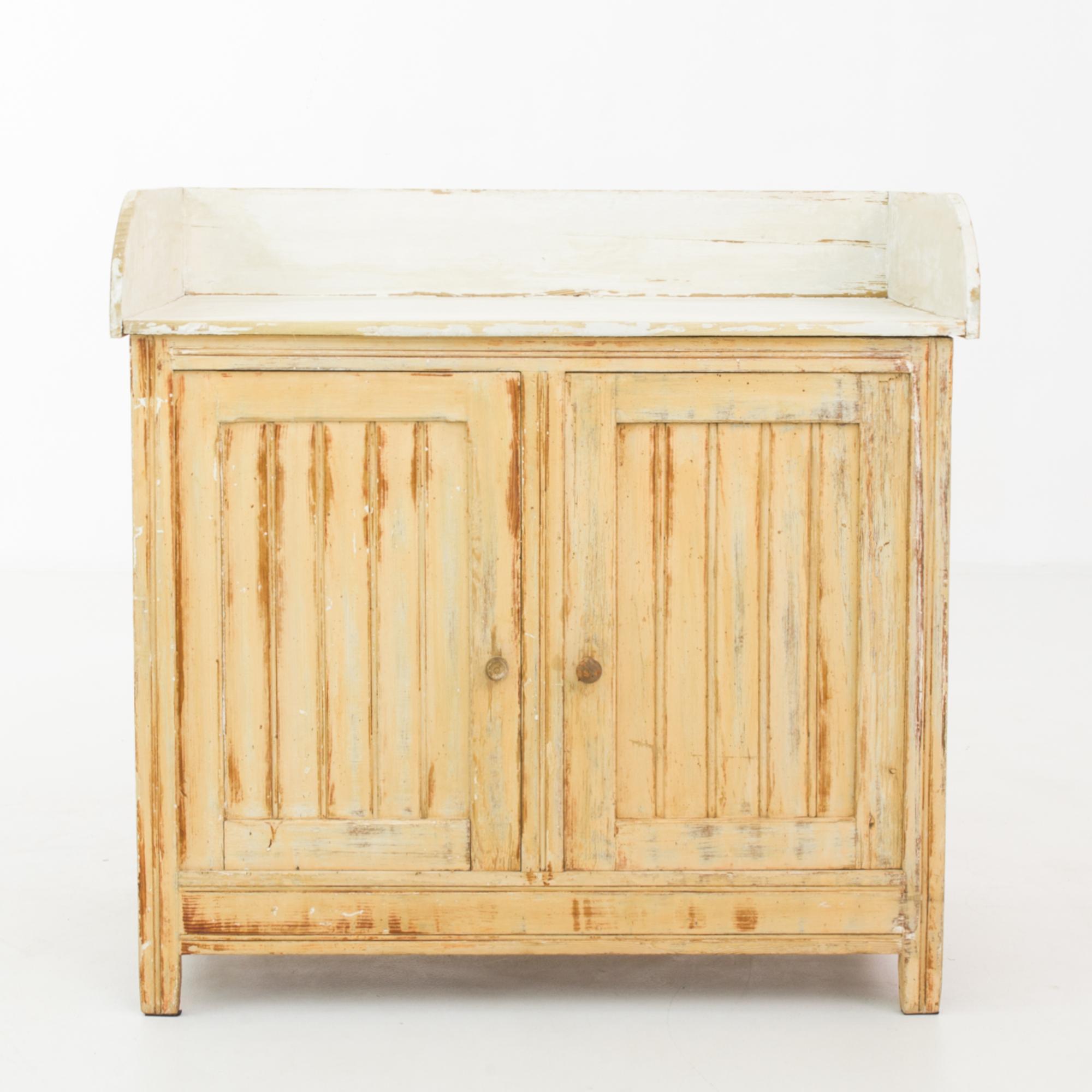 A patinated wooden cabinet from France, made circa 1900. Originally holding a freestanding wash basin, this classic bodied buffet chest of treated wood features a double door cabinet with two shelves, and a white painted wooden surround. Subtle