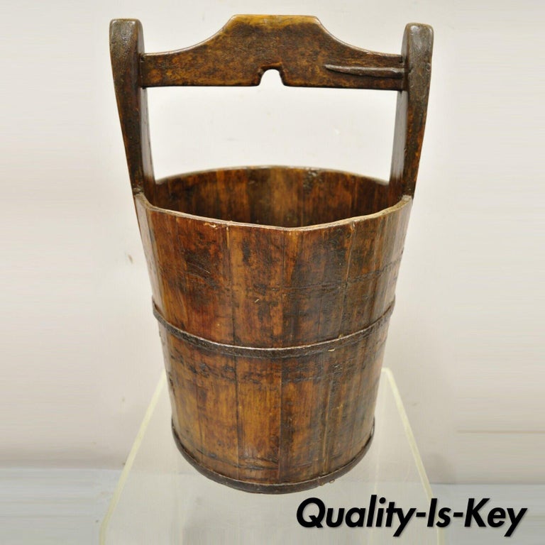 Antique French Country primitive large wooden water well bucket pail with handle. Item features cast iron bands, carved handle, solid wood construction, distressed finish, very nice antique item. Circa early to mid 1900s. Measurements: 22.5