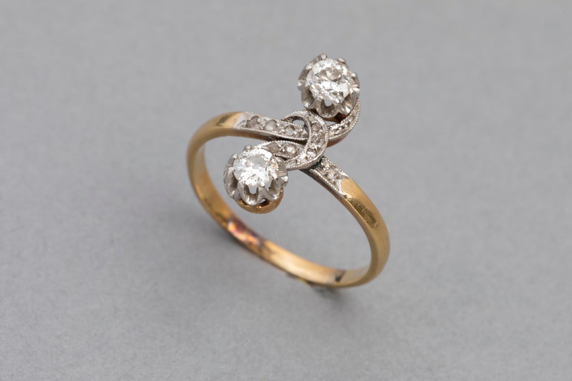 Very lovely antique ring. Crossover or Toi et moi shape designed.

Made in France circa 1910 (edwardian? )

Mounted with yellow gold 18k and platinum  (French control marks: Owl and Old man)

Set with two beautiful Round old european curt diamonds