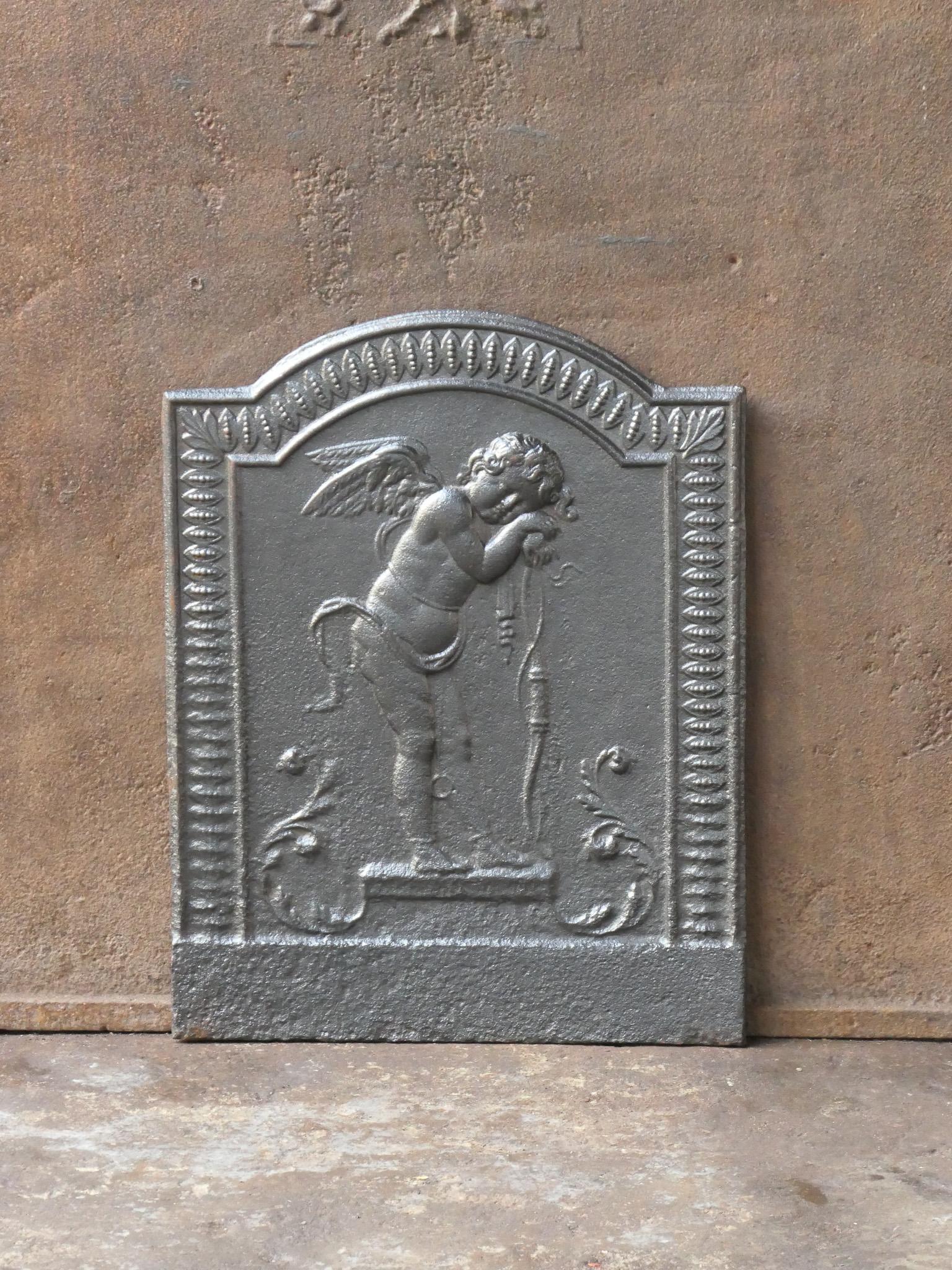 18th - 19th century French neoclassical period fireback with a cupid.

The fireback is made of cast iron and has a black / pewter patina. It is in a good condition and does not have cracks.