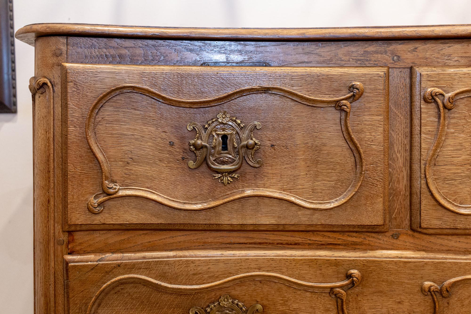 This gorgeous curved-front chest of drawers is French and features a five-drawer configuration, each with wonderful decoration and cast brass hardware. The escutcheon plates at the centre feature various musical instruments and floral imagery, while