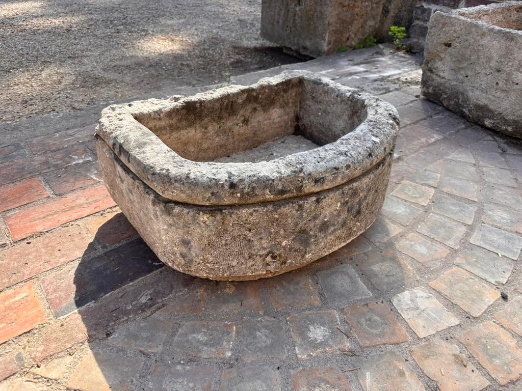 Taillée à la main dans un seul bloc de pierre calcaire, cette vasque témoigne du savoir-faire rustique et de la qualité durable de l'époque. Il présente un design en forme de D très recherché, avec une façade gracieusement incurvée et un dos plat,