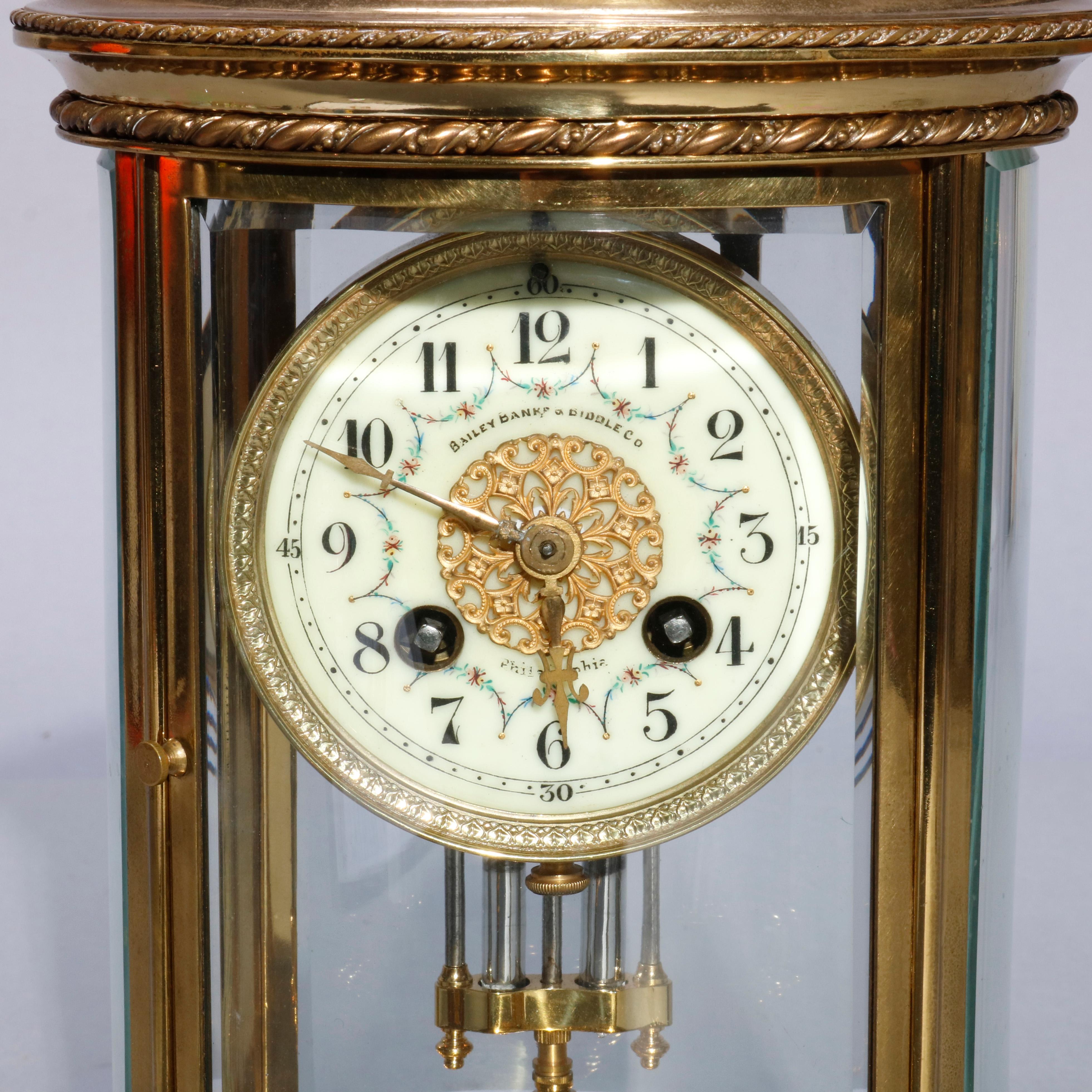 An antique French Medaille D'argent regulator clock retailed by Bailey, Banks and Biddle of Philadelphia, Pennsylvania (PA) offers brass and crystal case with floral decorated and retailer signed enameled face having Arabic numerals, 1889 Medaille