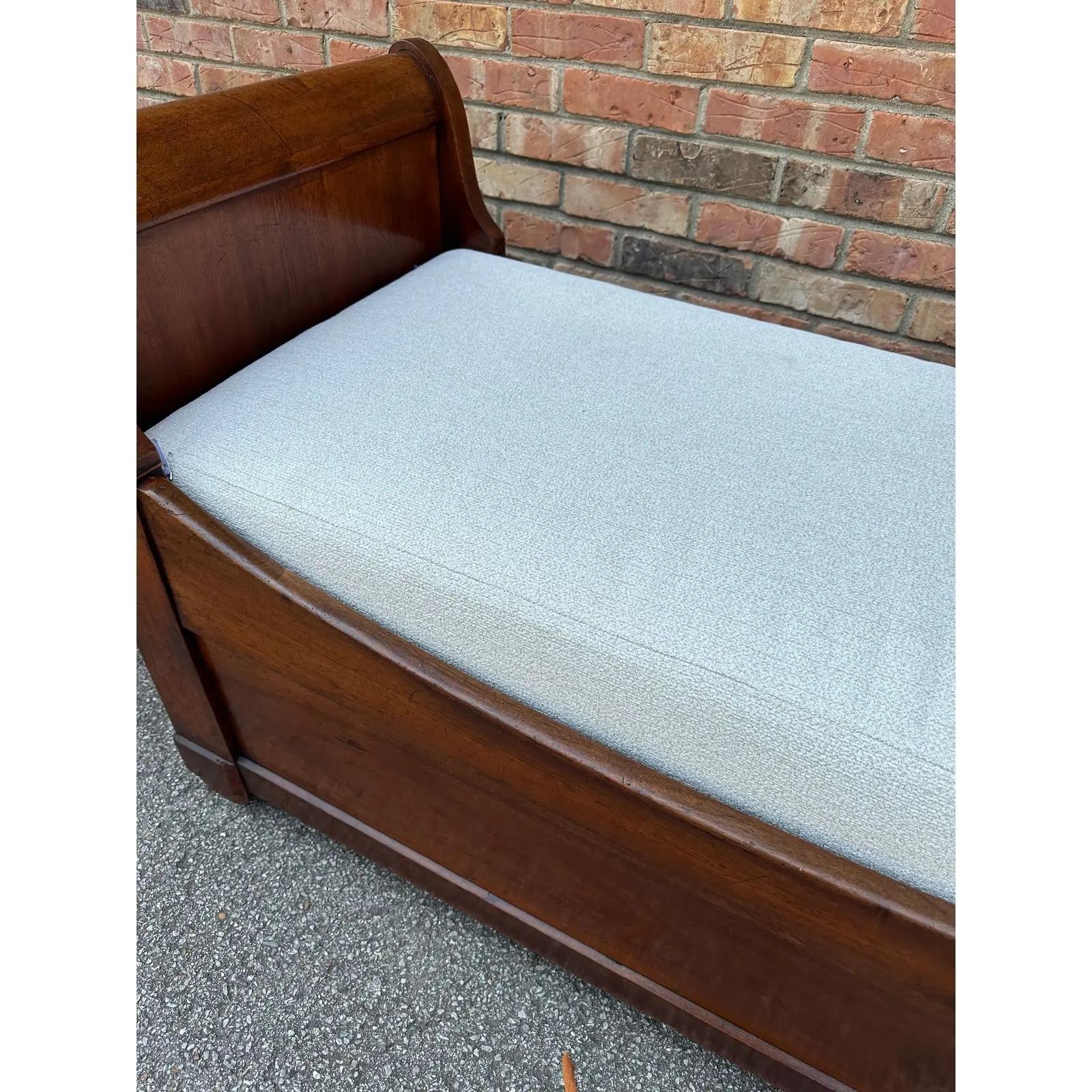 This is such a beautiful antique French day bed! The design is simple but so appealing with its curved edges and sleigh bed style. The wood is dark and glossy with lovely natural detail, and the cushion has been newly upholstered with a white