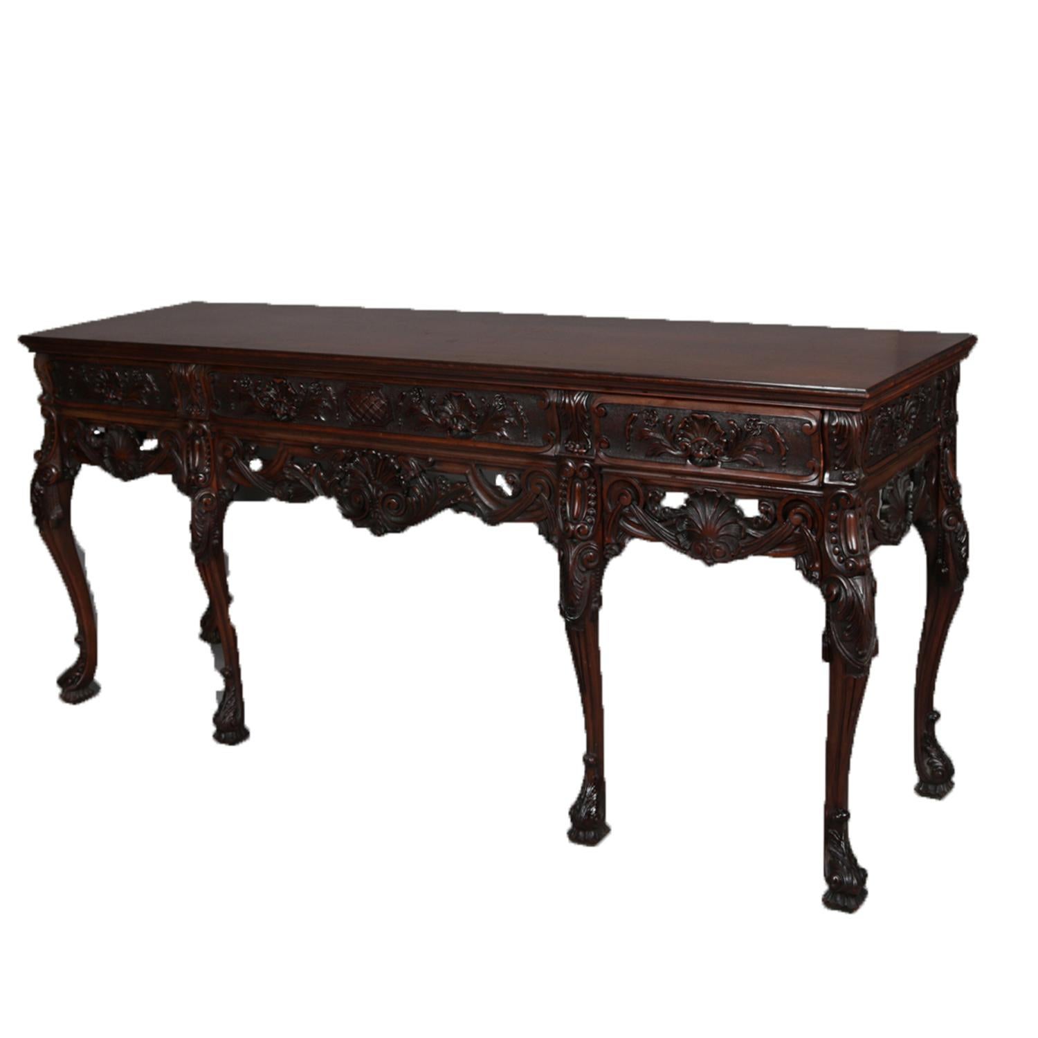 Antique French sideboard features walnut construction with central frieze drawer flanked by smaller side drawers each with carved shell and foliate decoration and over pierced apron having shell with flanking scroll and foliate carving, raised on