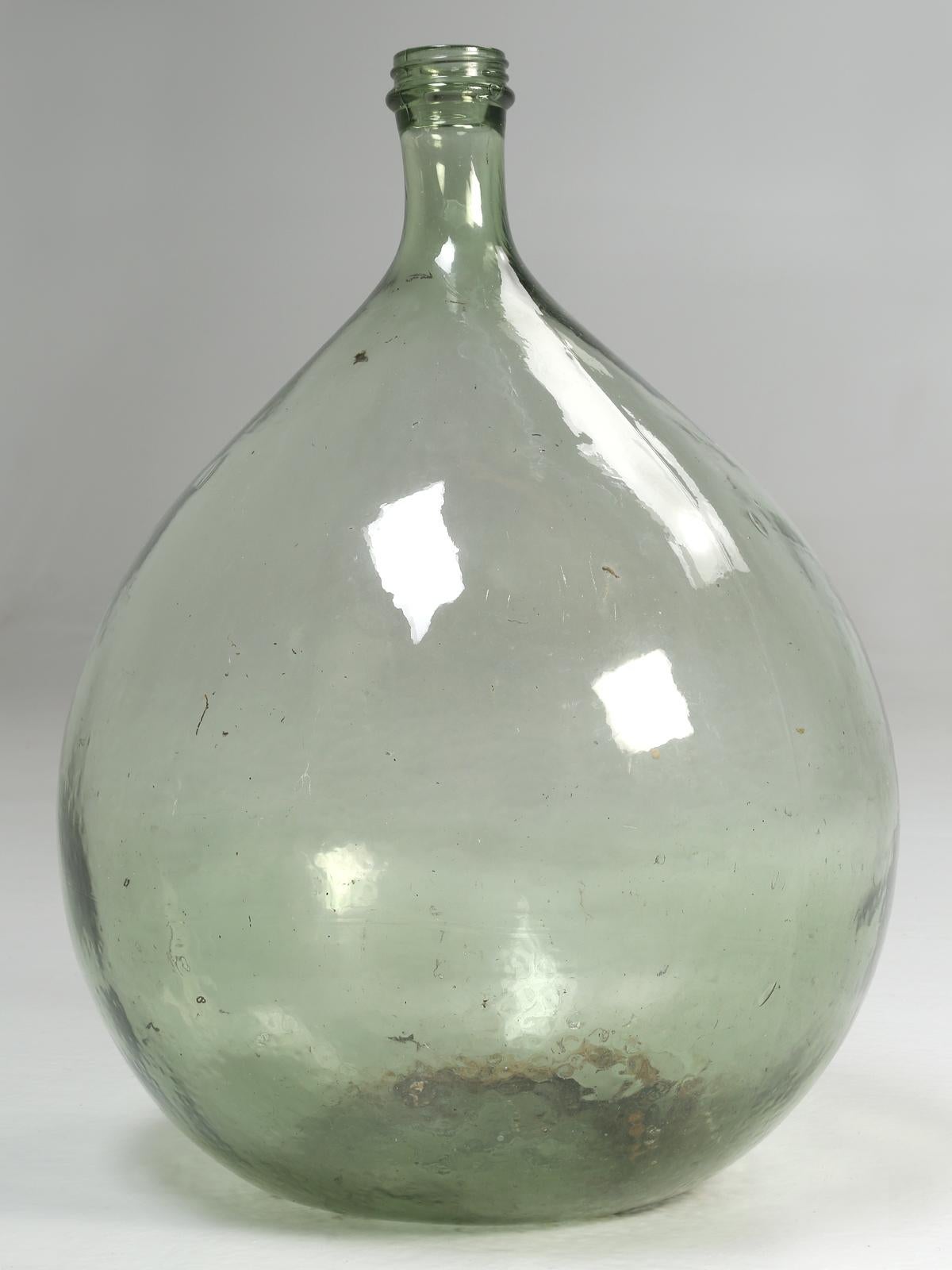 The Carboy name is from the Persia meaning big jug. Demijohn is French and is derived from, dame-Jeanne or Lady Jane. The glass containers were commonly used for in-home fermentation of wine or several other beverages.
Bottom reads, 