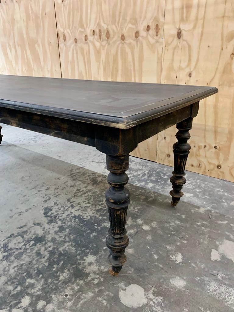 Large antique French dining table in blackened wood. The dining table dates from circa 1900, can easily fit 10 people for dinner, and has great patina. It is not heavy, but can be moved around easily because of the small wheels at the end of the