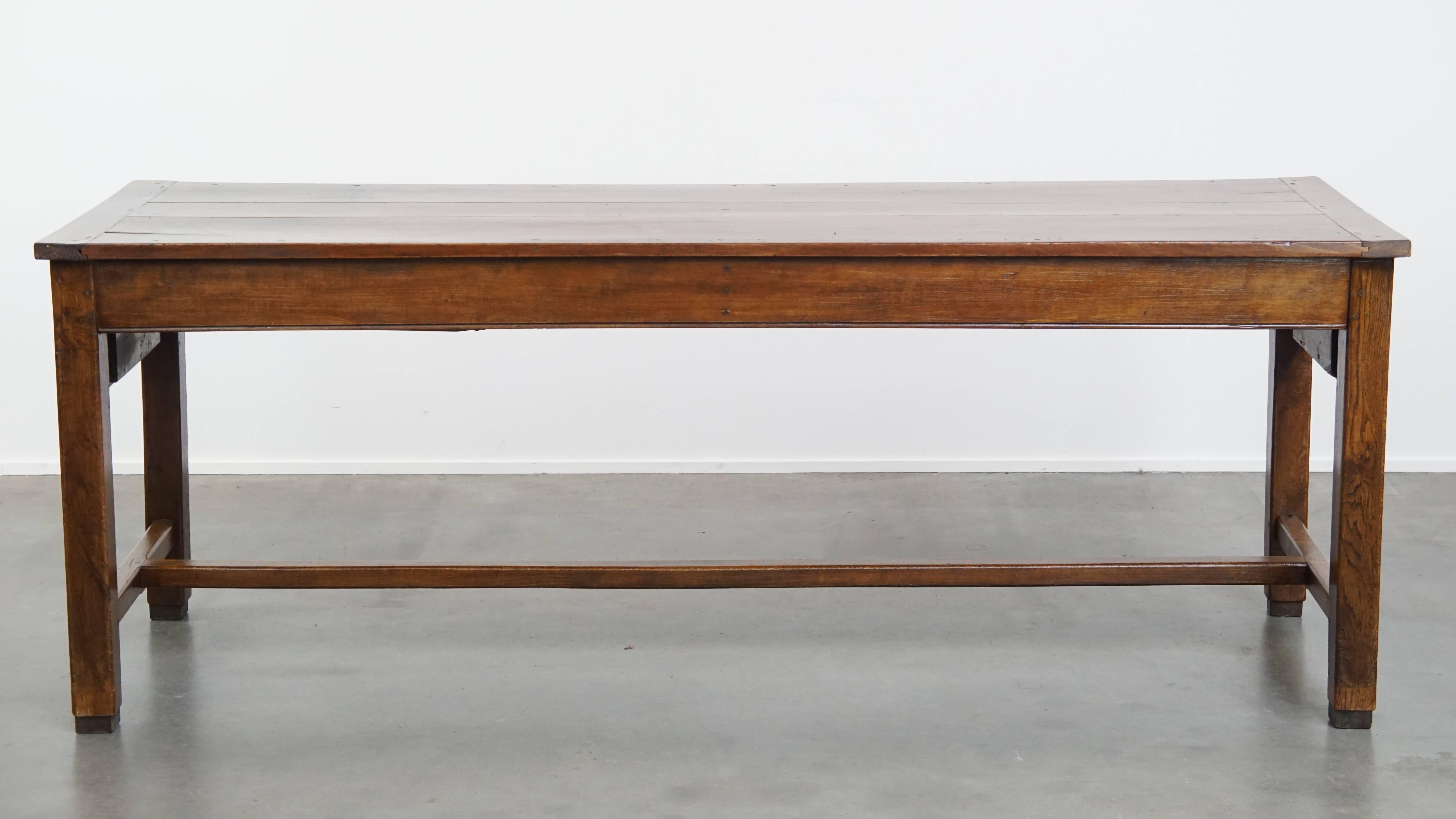 Offered here this magnificent antique French dining table in fruitwood from the 18th century, featuring 2 drawers and a lovely patina.
This impressive antique French dining table, crafted from fruitwood, dates back to the 18th century and has