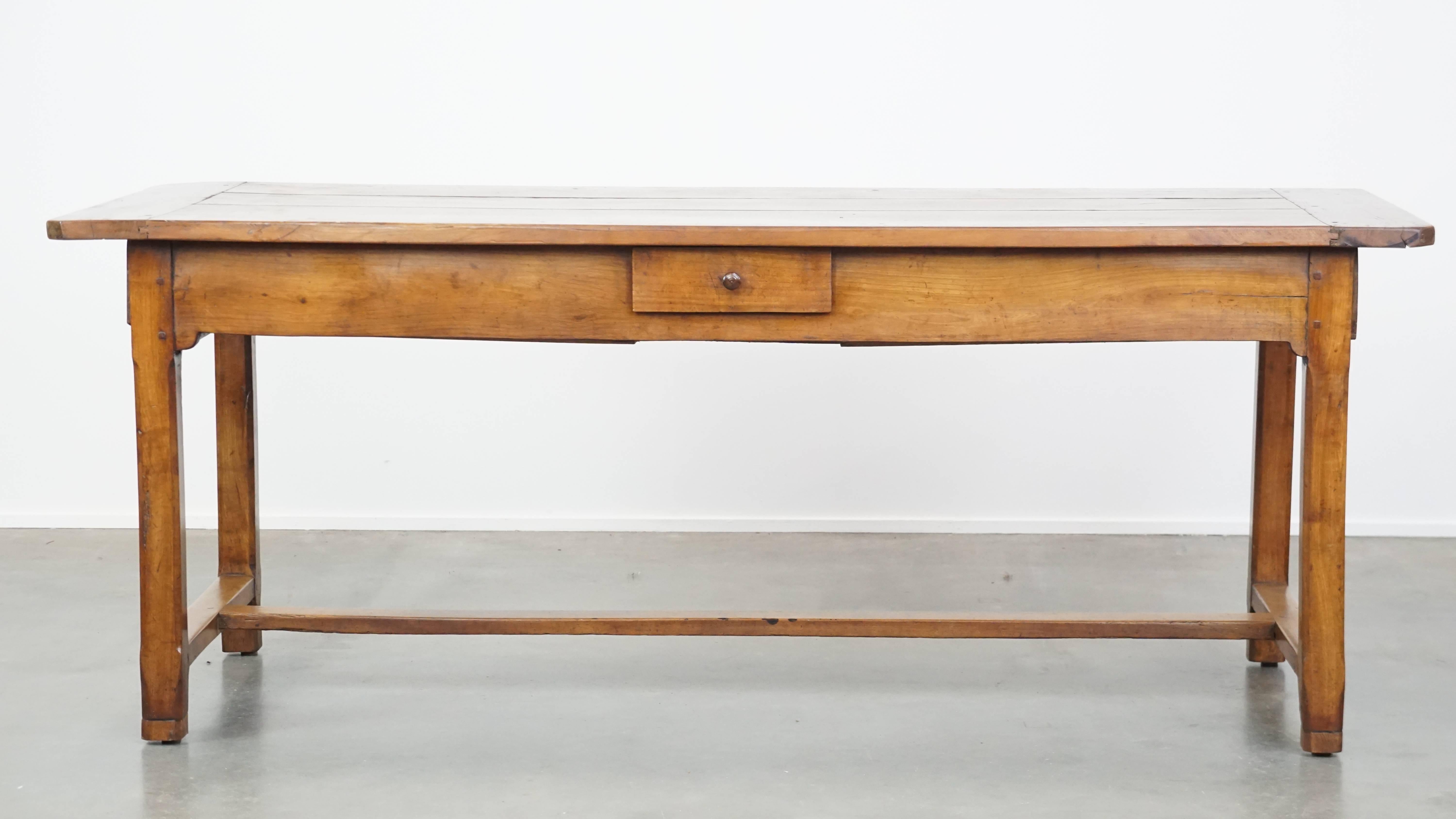 Cette belle table à manger française ancienne de la fin du XVIIIe siècle est fabriquée en bois de fruitier et est pratiquement conçue avec trois tiroirs pour un rangement supplémentaire. Comme cette table a été élevée de manière experte, elle peut