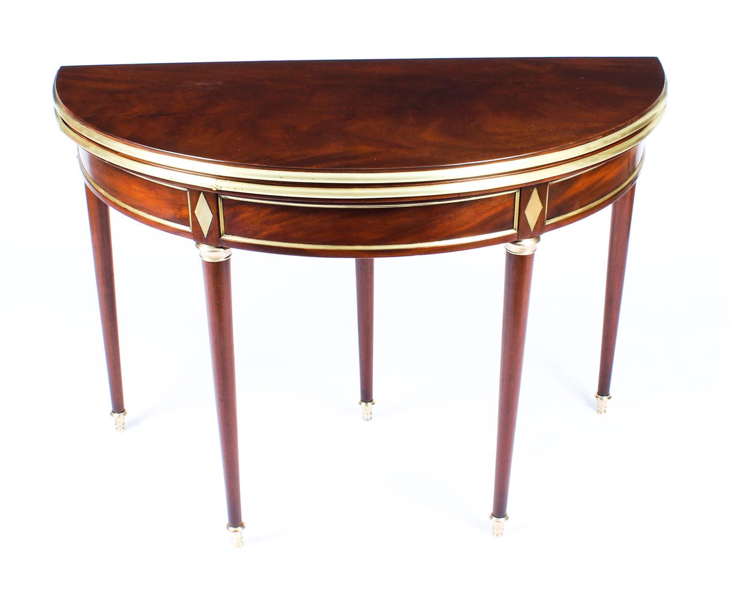This is a very attractive antique French Directoire flame mahogany and brass mounted demi-lune ganes table, circa 1820 in date.

The folding top opening to reveal a baize lined playing surface, the central rear leg extending with a concealed drawer