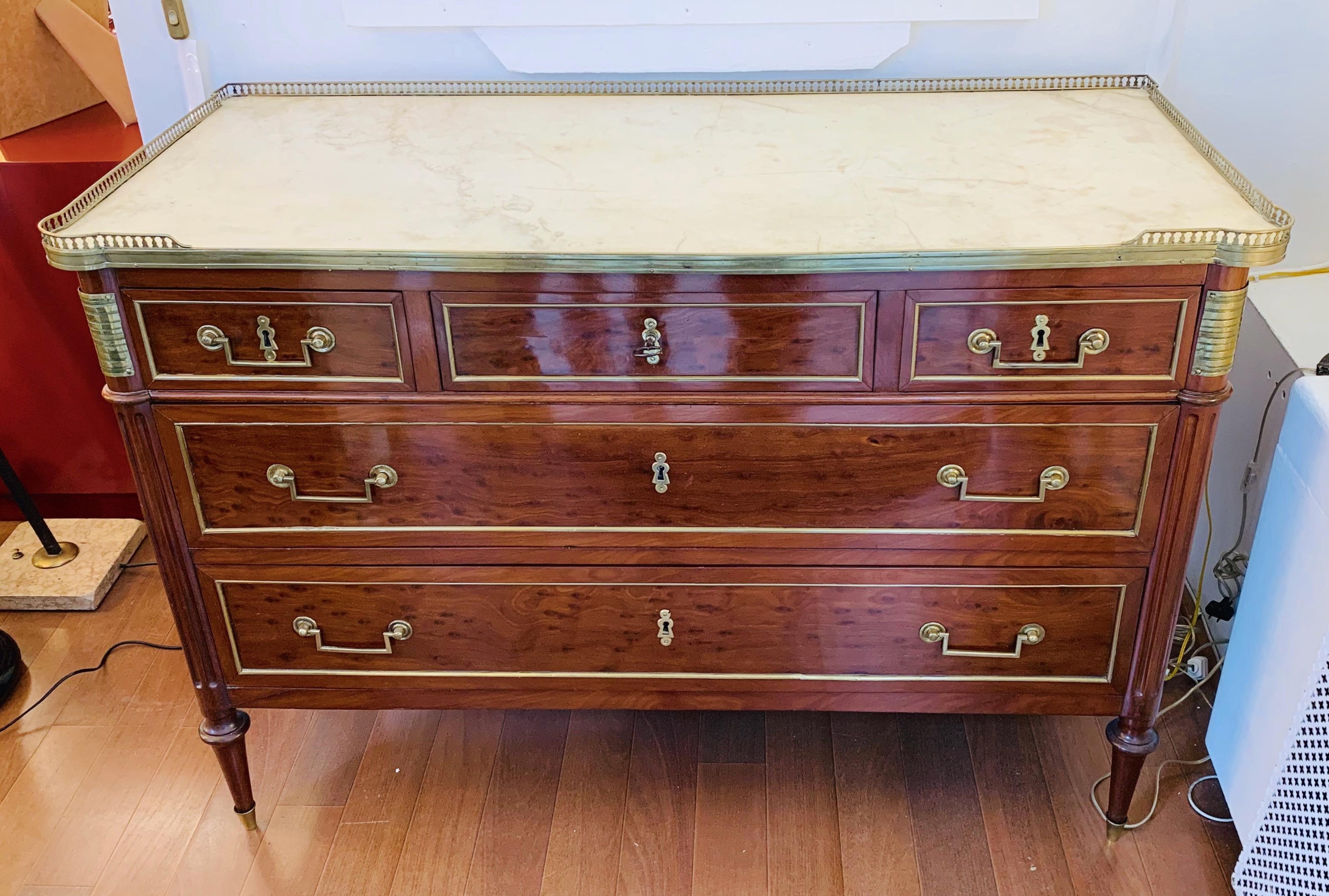 French Directoire chest of drawers, with galleried original top in gray veined white marble, decorated with brass stringing lines and moldings at the feet as well as chased brass plaques on the rounded corners, circa 1795- 1810. A special Empire
