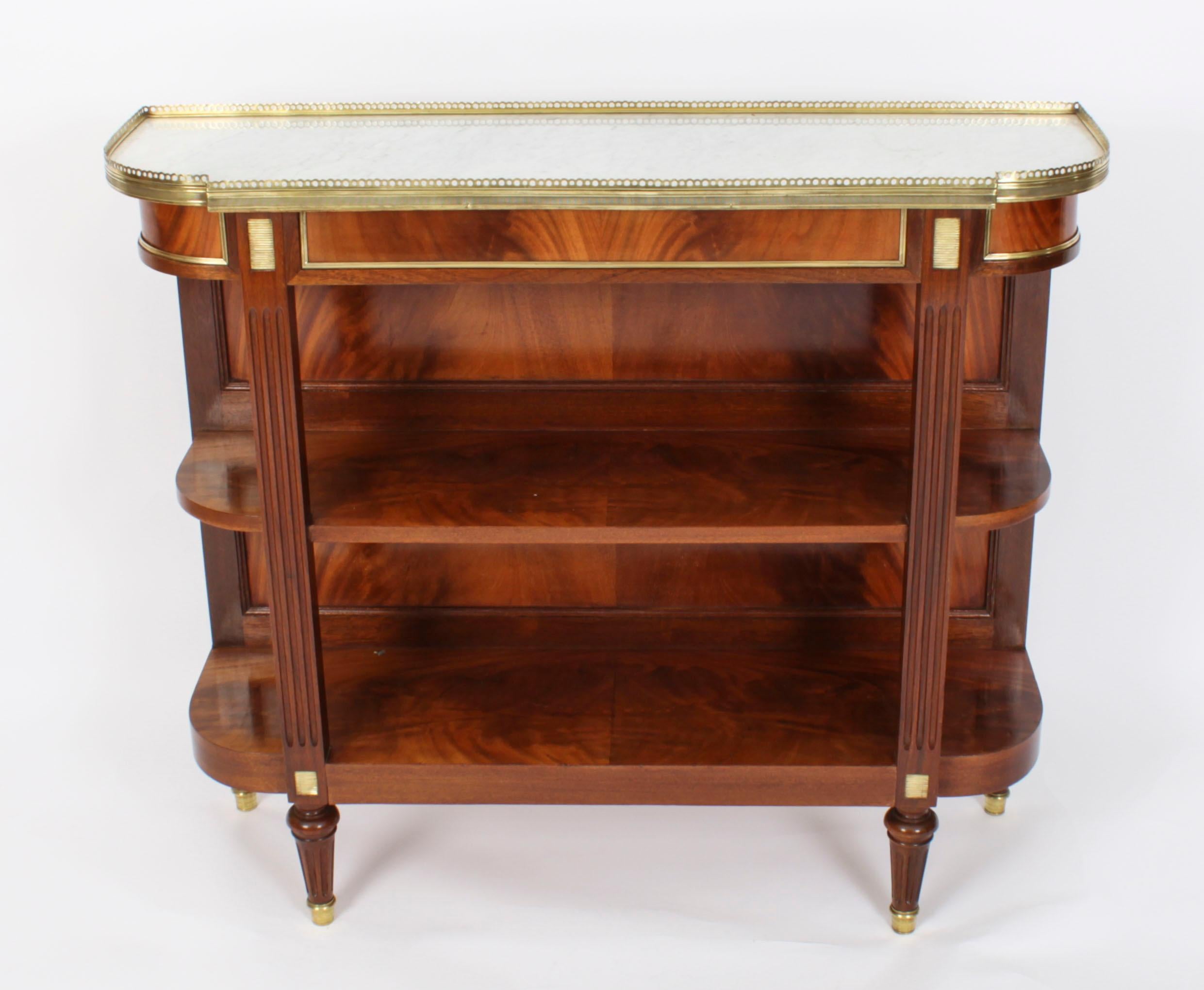 This is an elegant antique French Directoire ormolu mounted flame mahogany marble topped buffet, dating from Circa 1840.
 
It features a striking serpentine galleried inset white Carrara marble top above a decorative panelled frieze. This is above