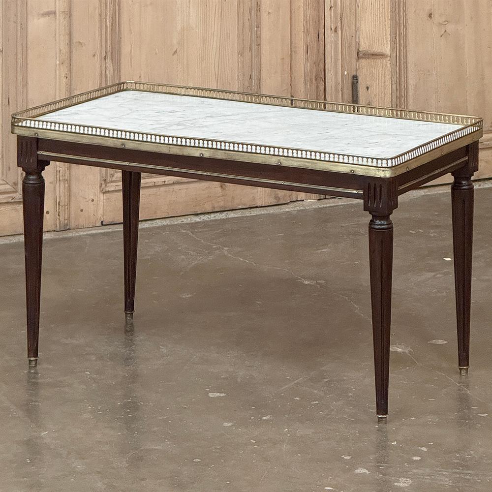 La table basse ancienne en marbre de Carrare Directoire représente l'essence même de l'élégance discrète !  On remarque immédiatement le luxueux marbre de Carrare qui recouvre le dessus, offrant une surface luxueuse mais sans souci pour vos