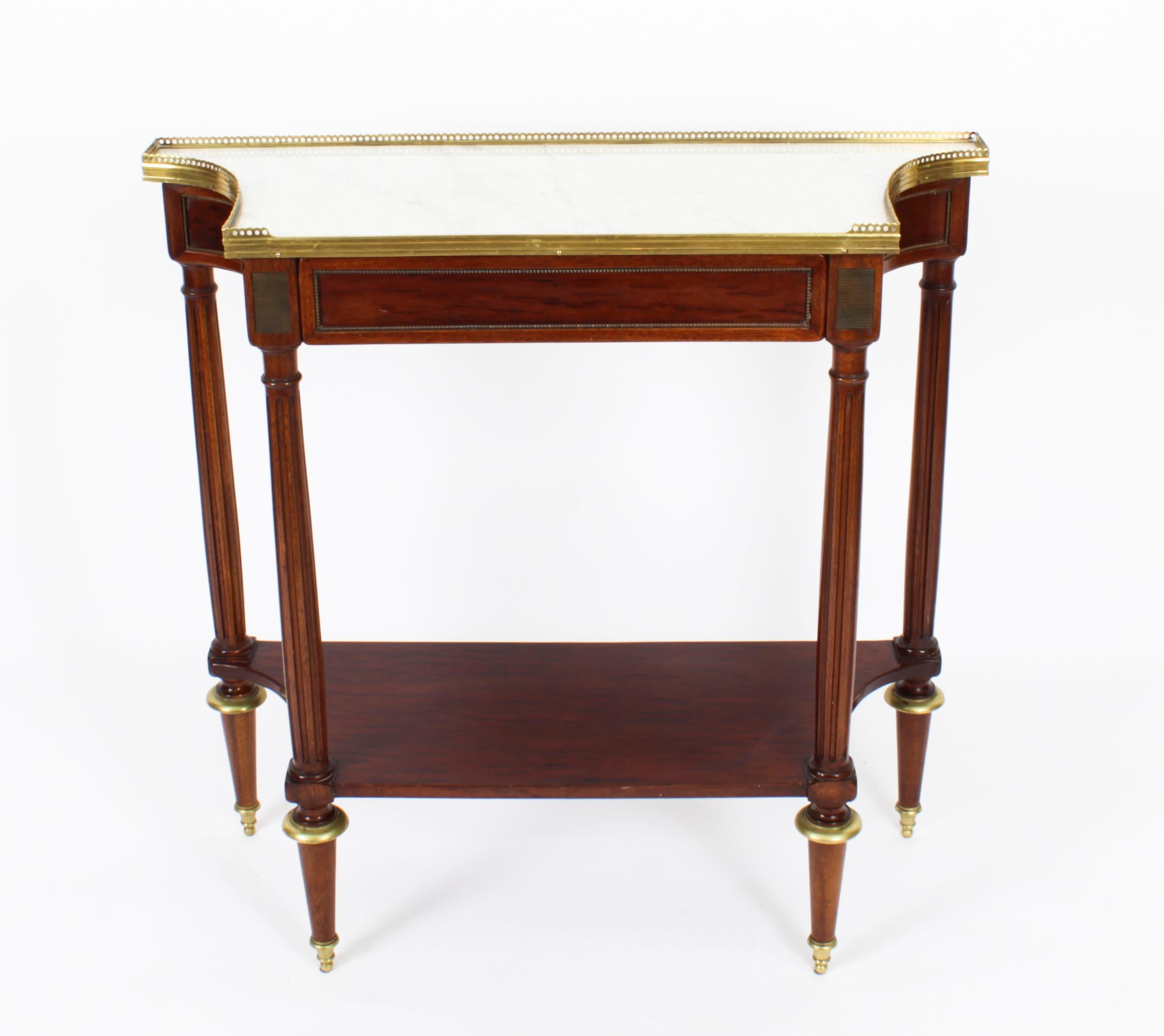 This is a fine antique French Directoire marble topped and ormolu mounted mahogany console table, dating from Circa 1840.
 
The shaped Carrara marble top features a decorative three quarter pieced brass gallery over a frieze drawer decorated with
