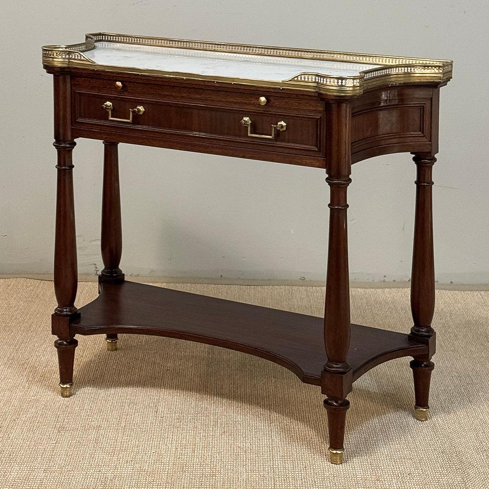 Antique French Directoire Mahogany Console with Carrara Marble Top expresses a tailored elegance that cannot be denied!  Crafted from solid mahogany, it features a shallow design with concave sides making it a very traffic-friendly addition to any