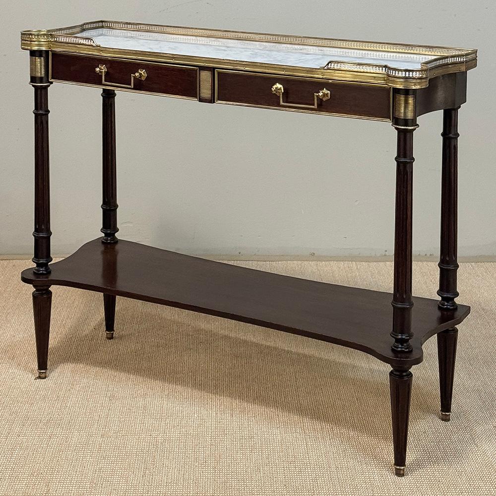 L'Antique French Directoire Mahogany Console with Carrara Marble Top esprime un'eleganza sartoriale che non si può negare!  Realizzato in mogano massiccio, presenta un design poco profondo con lati concavi che lo rendono un'aggiunta molto trafficata