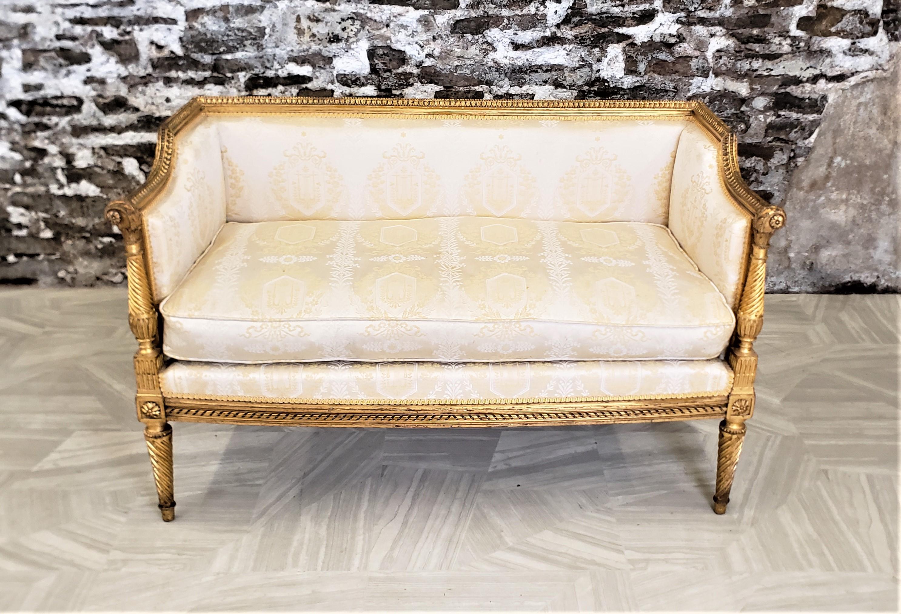 This settee shows no maker's signature, but presumed to have originated from France and dating to approximately 1900 and done in a Directoire style. The printed cream fabric is framed with elaborately hand-carved wood with a gilt finish with