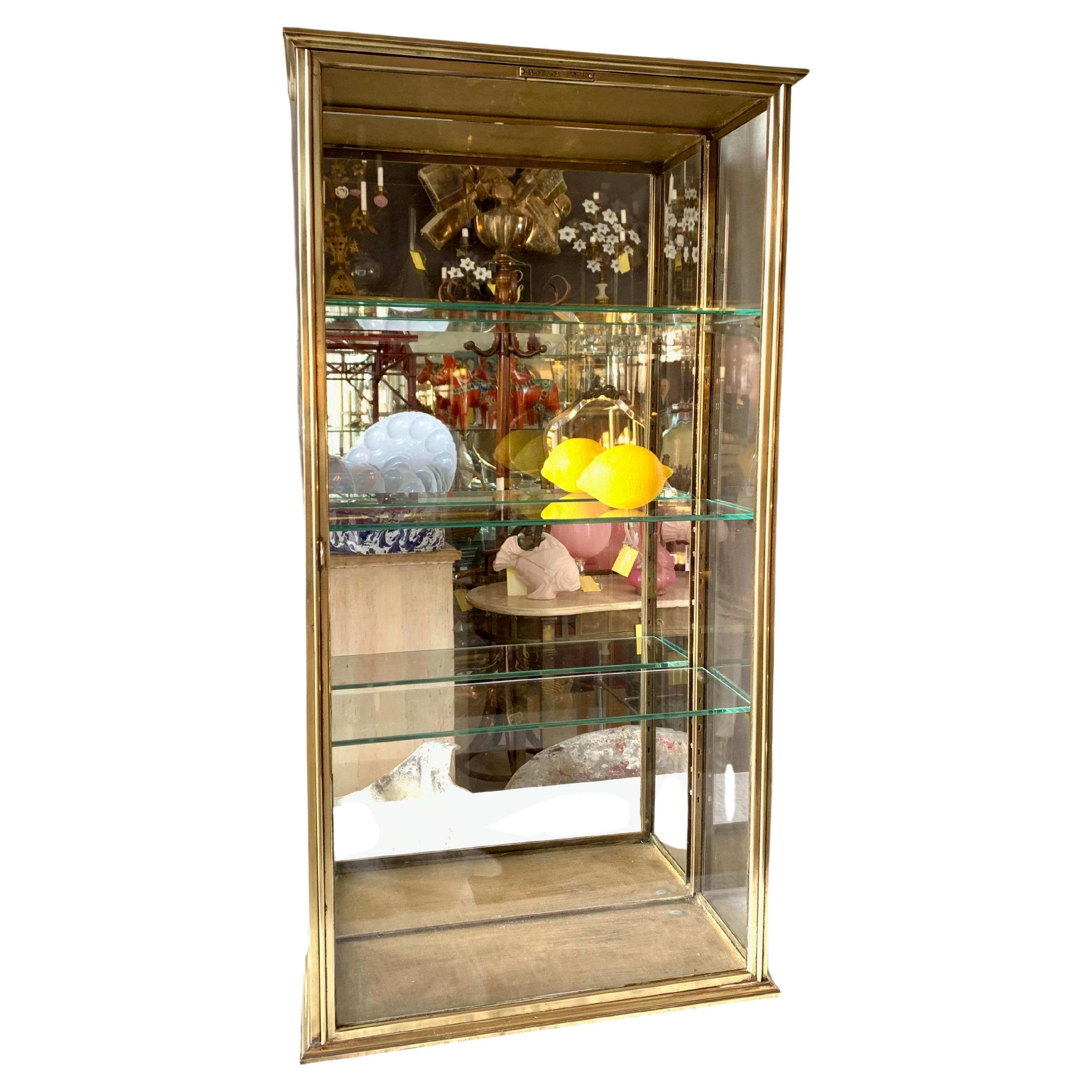 Antique French brass display cabinet or vitrine for hanging on the wall. The cabinet has perfect patina according to its age and used to serve as a display for tobacco, perfume etc. in a shop. A nice cabinet for the kitchen, bathroom or dressing