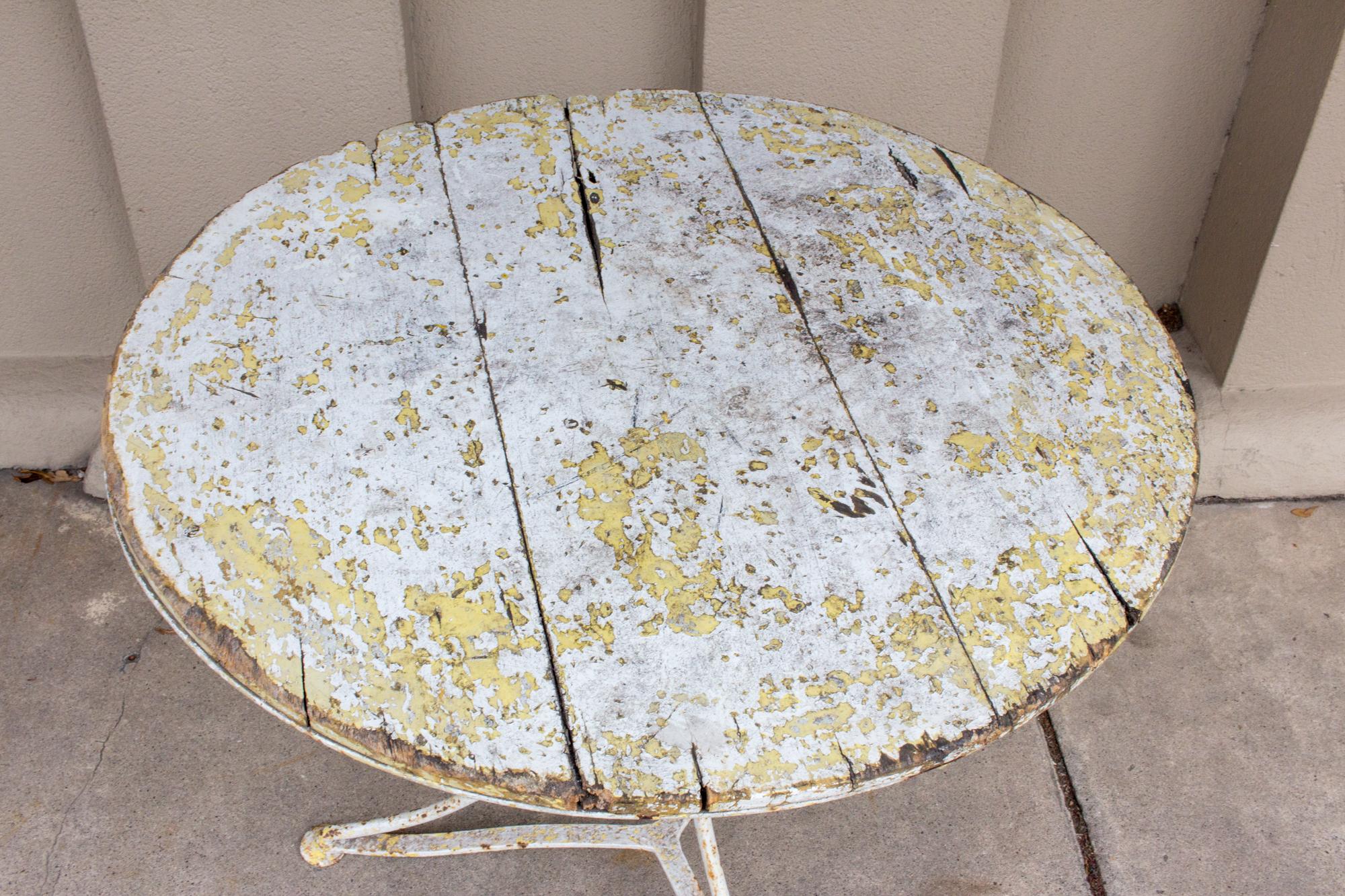 The distressed painted finish on this wonderful iron and wood bistro table is simply fantastic. Uncovered in France, this table has miles of character. The curved legs and generous top make this a perfect place to perch cocktail glasses or a