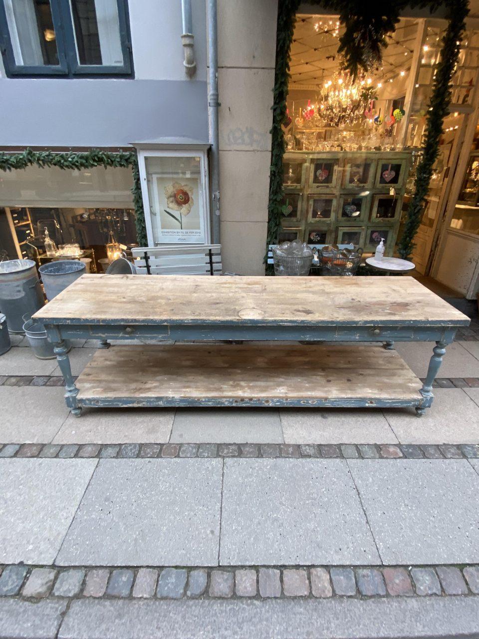 Beautiful antique French console / drapery table, consisting of a shelf underneath going its full length, and two drawers. Circa year 1900, and originally boutique inventory furniture.

The surface is in a genuine raw and rustic wood, and with a