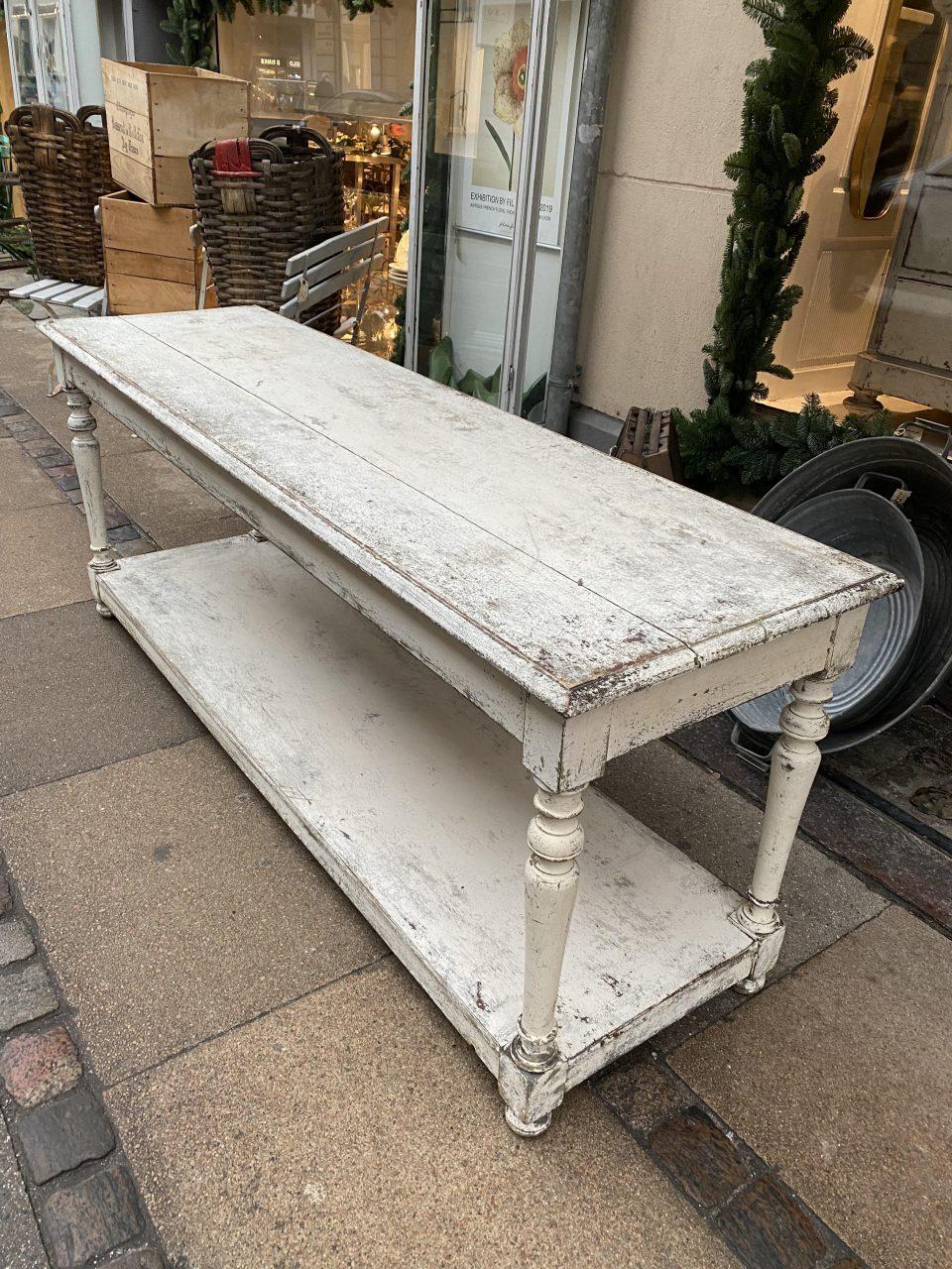 Sophisticated, stunning and well-proportioned console table / drapery table, painted a whitish tone. France circa 1900. Originally boutique inventory, for the storage, presentation and measuring of fabric rolls / textiles.

Elegant yet also raw