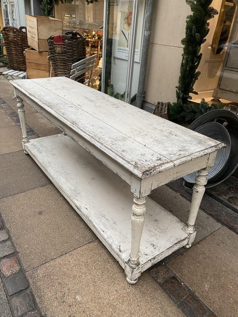 Sophisticated, stunning and well-proportioned console table / drapery table, painted a whitish tone. France circa 1900. Originally boutique inventory, for the storage, presentation and measuring of fabric rolls / textiles.

Elegant yet also raw