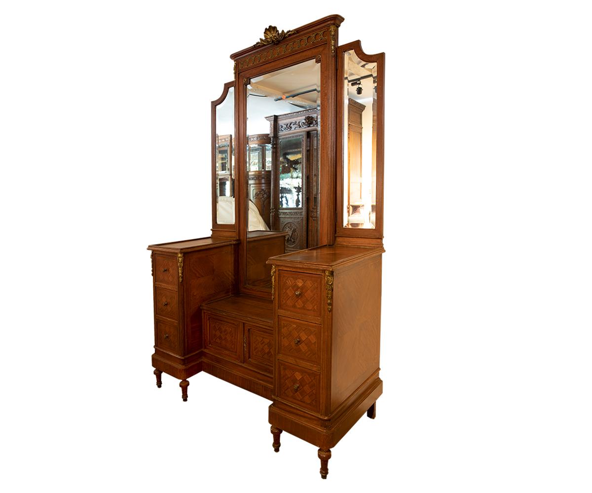 Antique French dressing / vanity table with original beveled mirrors. The side mirrors are movable with three deep drawers on each side and two door small cabinet in the middle of the dresser. On top and side gilded ormolu decoration adds elegance