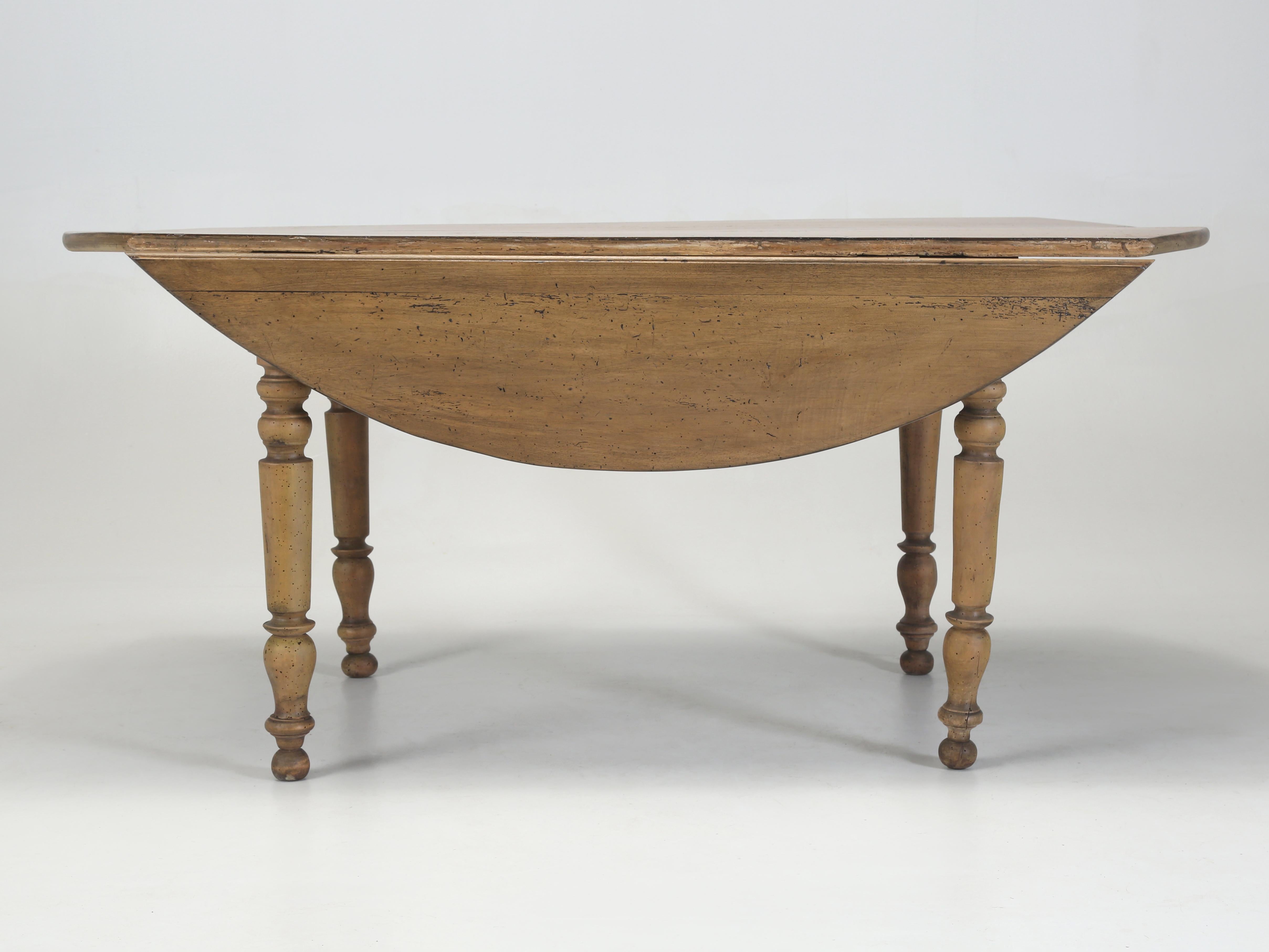Antique French Drop Leaf Dining, Kitchen Table Recently Restored circa mid-1800's. Our drop-leaf dining table was constructed out of beautiful and unique French Walnut, which is appreciably different than our much darker American Walnut. The Dining