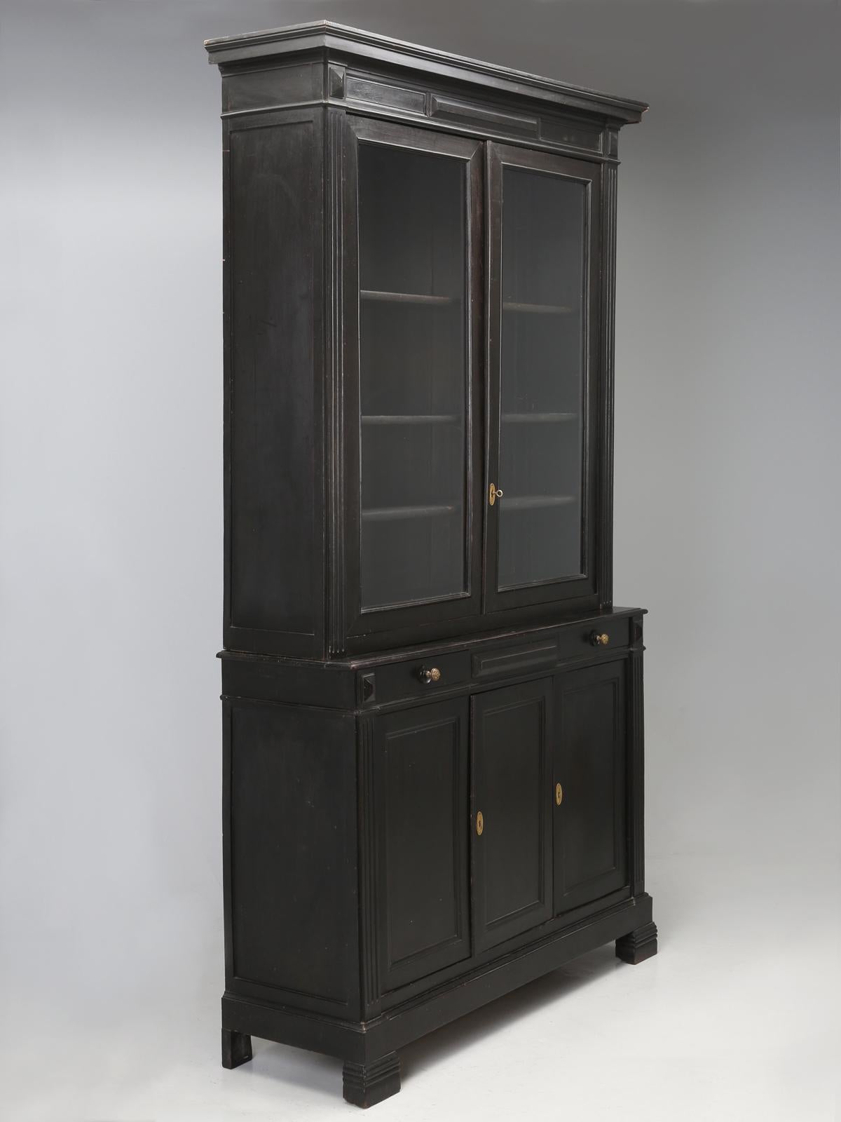 An original ebonized bookcase, bibliotheque, display or china cabinet and by the word original, we are referencing, that this is not a newly doctored up antique French black cabinet, painted to look ebonized, but rather, a 100%, untouched, all