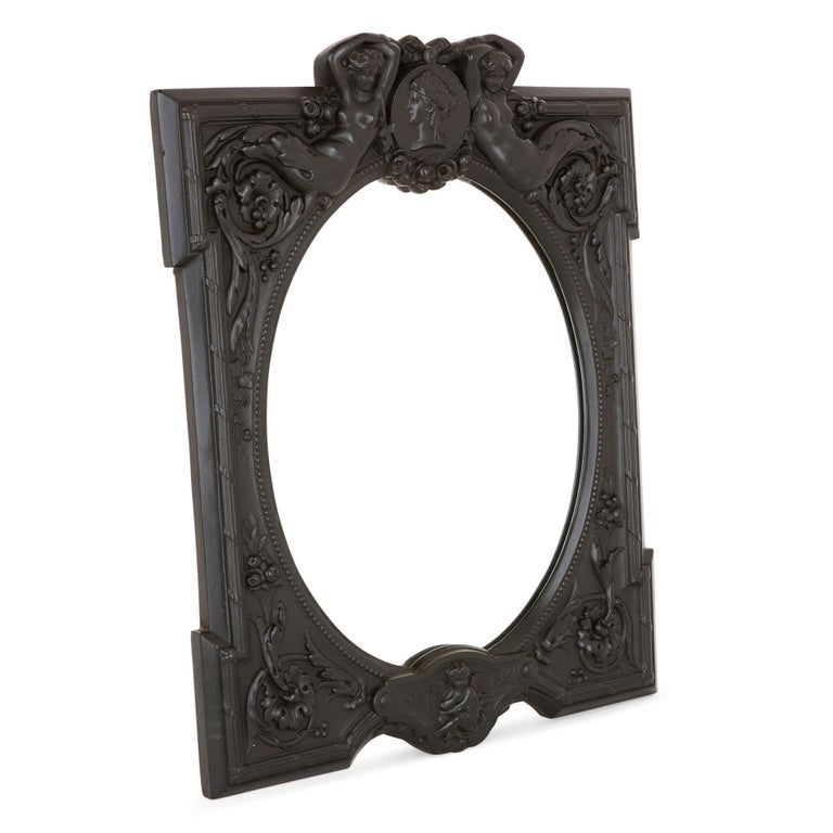 This beautiful mirror will look wonderful placed on a woman’s dressing table. It features an ebony frame which is intricately carved with a variety of motifs, inspired by classical design. 

The item is composed of an oval mirror, which is set