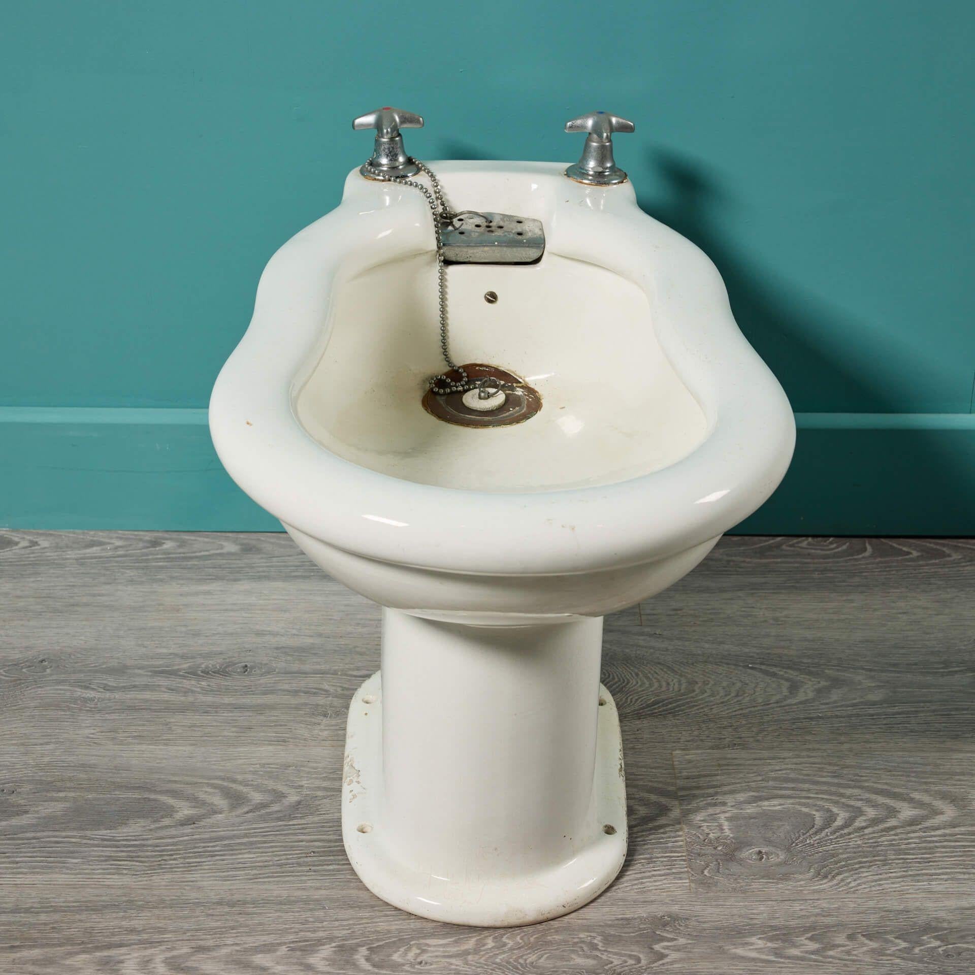 An antique French Edwardian porcelain bidet dating to circa 1920. This early 20th century piece has a smooth curved shape and crisp finish, which would make for a stylish addition to a bathroom in a contemporary or period property, such as a