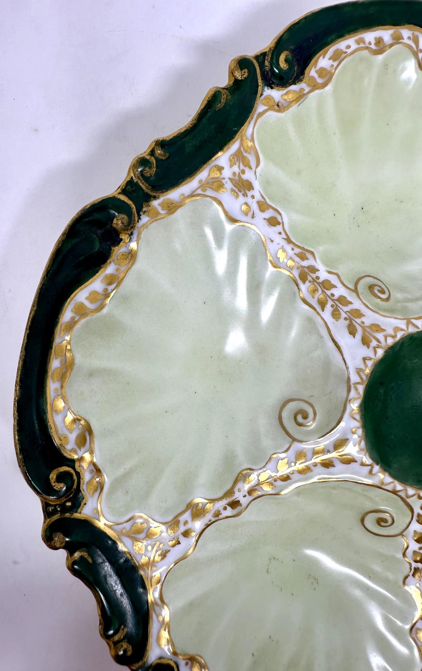 Ancienne assiette à huîtres en porcelaine de Limoges verte et or, Circa 1890-1900.
Plaque en forme d'huître dans des tons frappants de vert forêt, d'or et de chartreuse pâle.