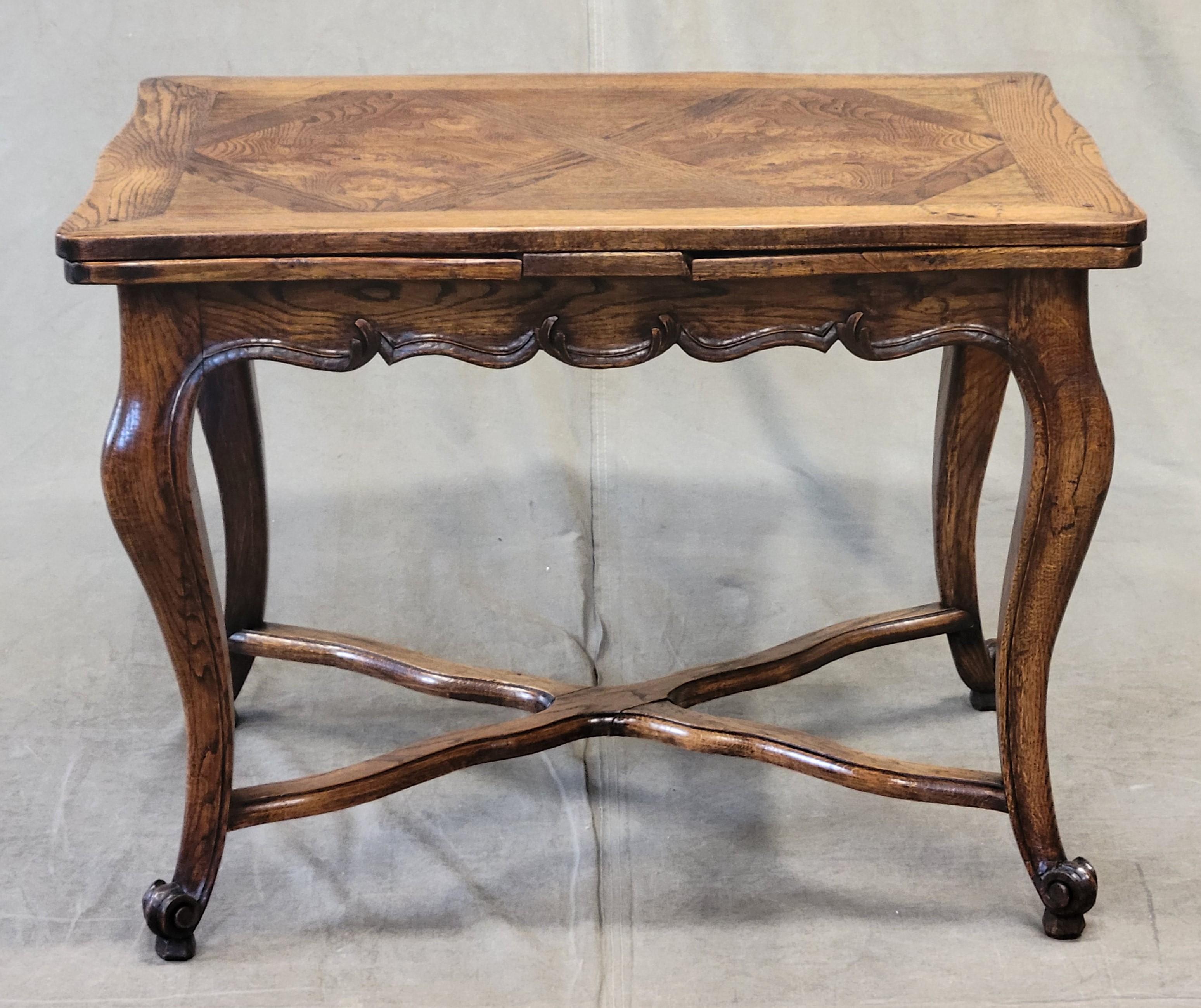 A gorgeous antique French draw leaf table with a solid elm frame and burl elm parquetry top. Leaves have been adjusted and pull out smoothly. The table easily transitions from a petite 39