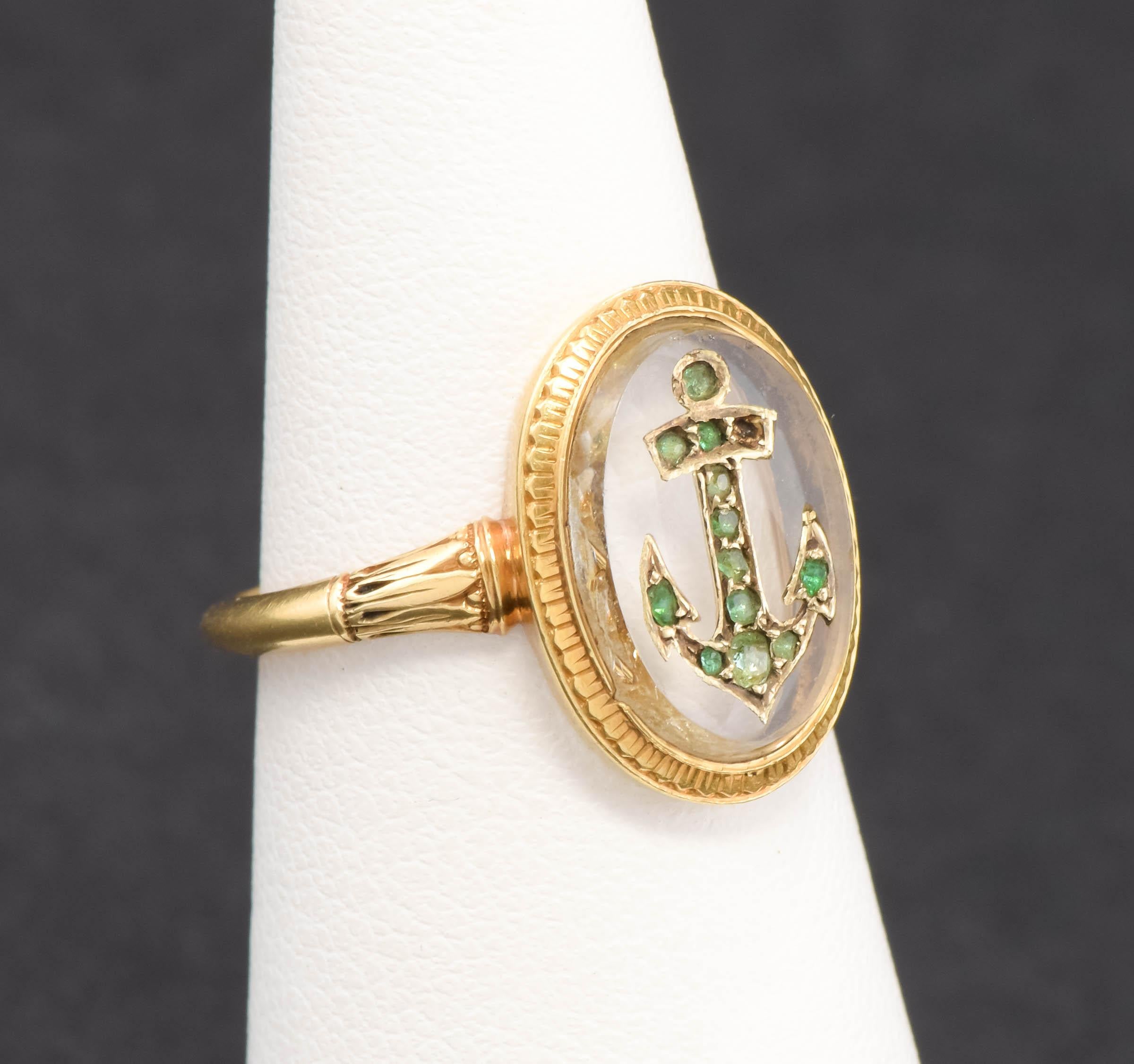 Offered is a very special and unique Victorian period gold ring featuring a Rock Crystal plaque inset with an Anchor design studded with old emeralds. 

(Please note that one emerald is currently missing as shown in my macro photos.  I have arranged