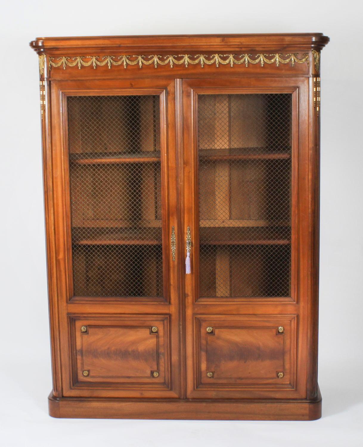 This is a superb antique French walnut and omolu mounted bookcase / Bibliotheque, dating Circa 1870 in date.

It has been hand crafted from solid walnut and decorated with fine Neo- Classical ormolu mounts consisting of bronze ribbons and palmette