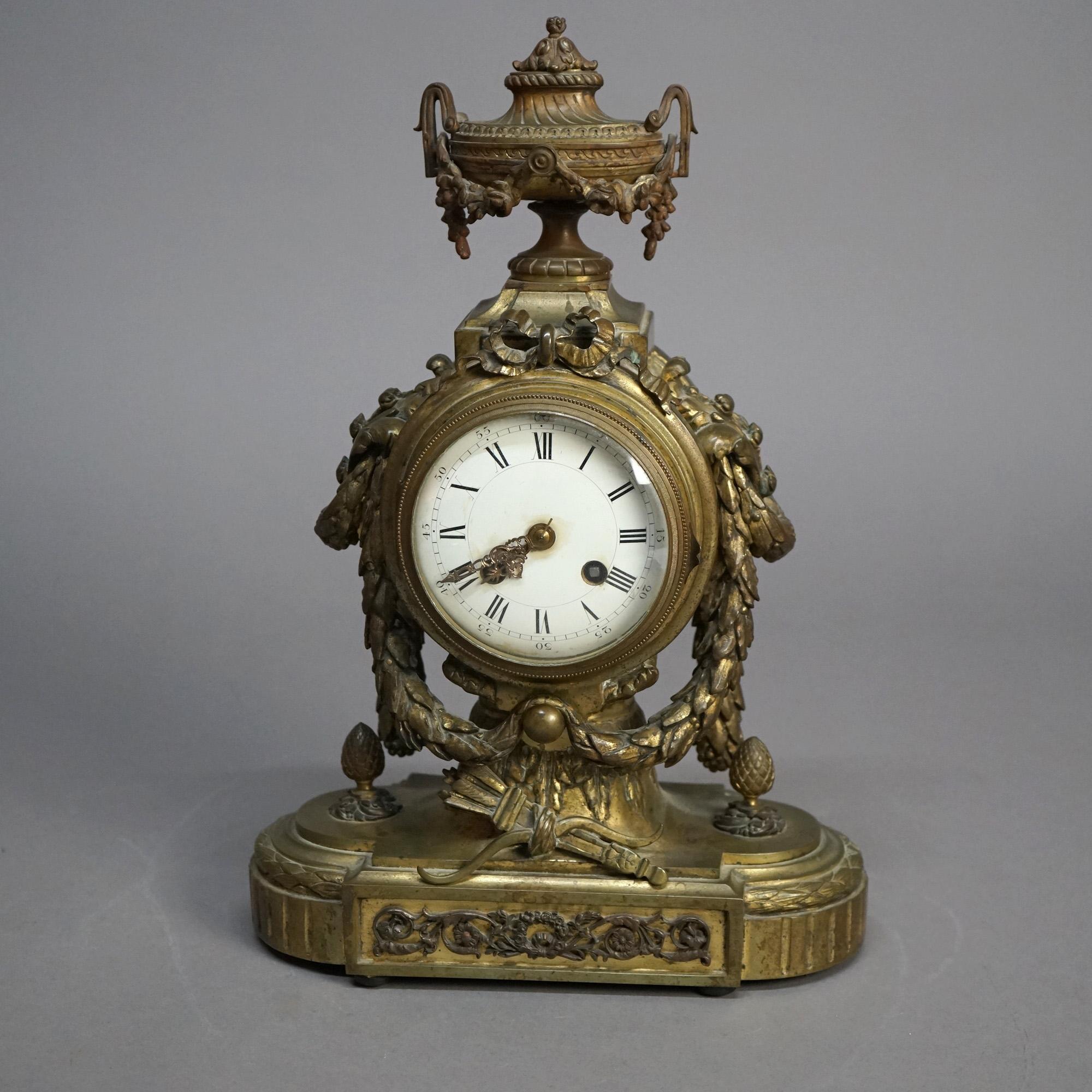 An antique French Empire mantel clock offers cast bronze construction with urn form finial and swag decoration, 20th century

Measures - 14.75